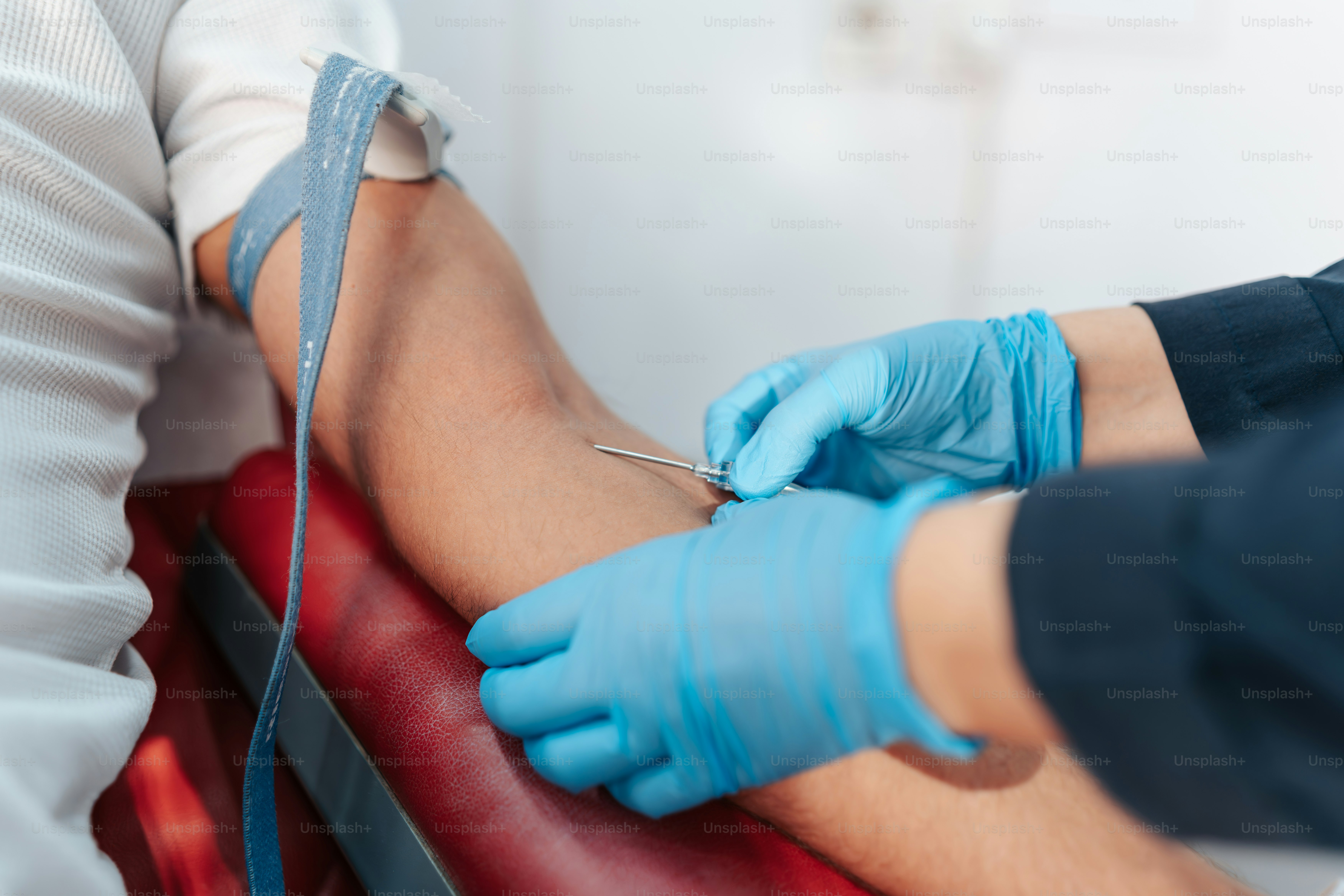 A person getting a vein on the leg of another person