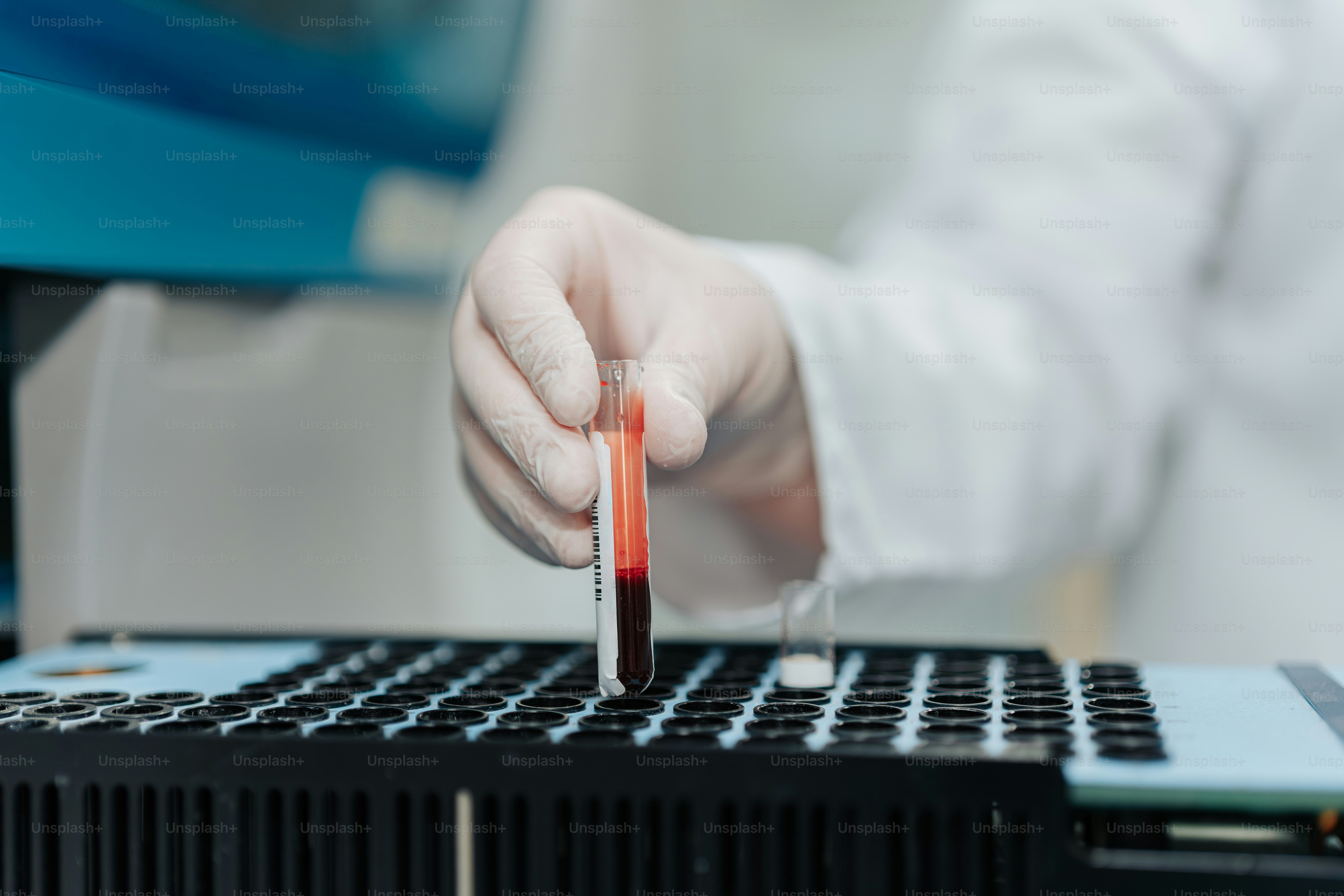 A person in a white coat is working on a laptop