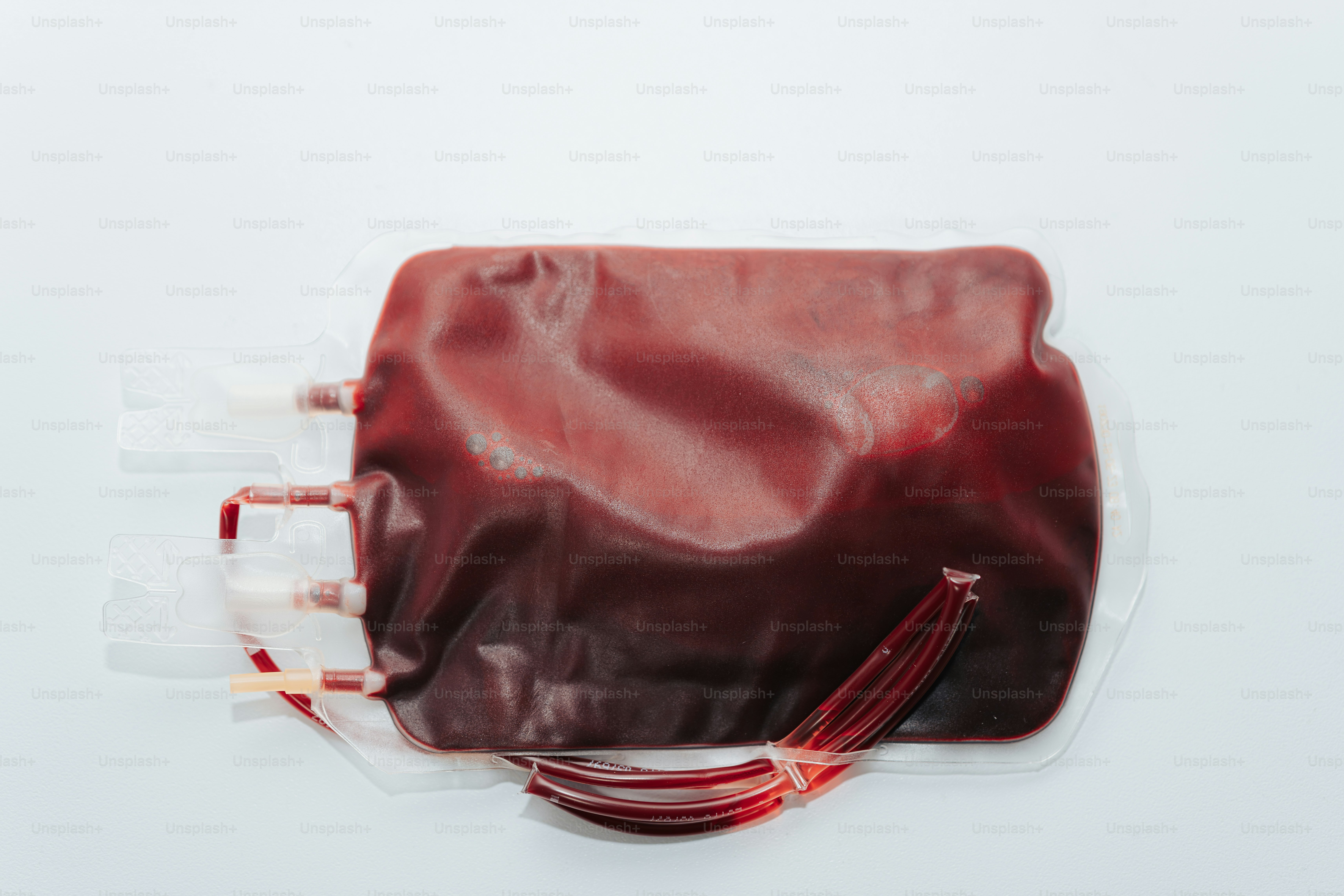 A plastic bag with a red handle on a white surface
