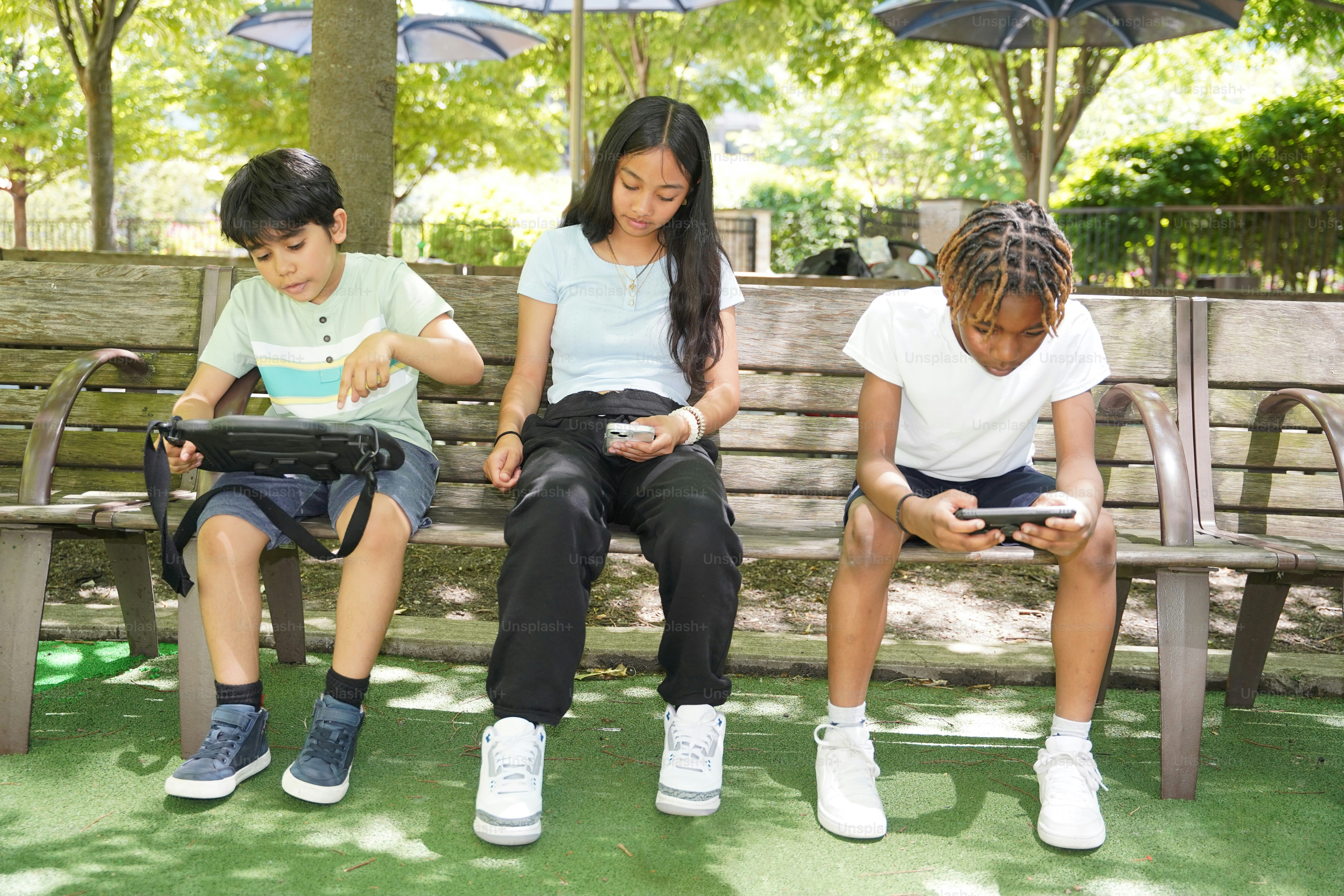 A group of children sitting on a park bench