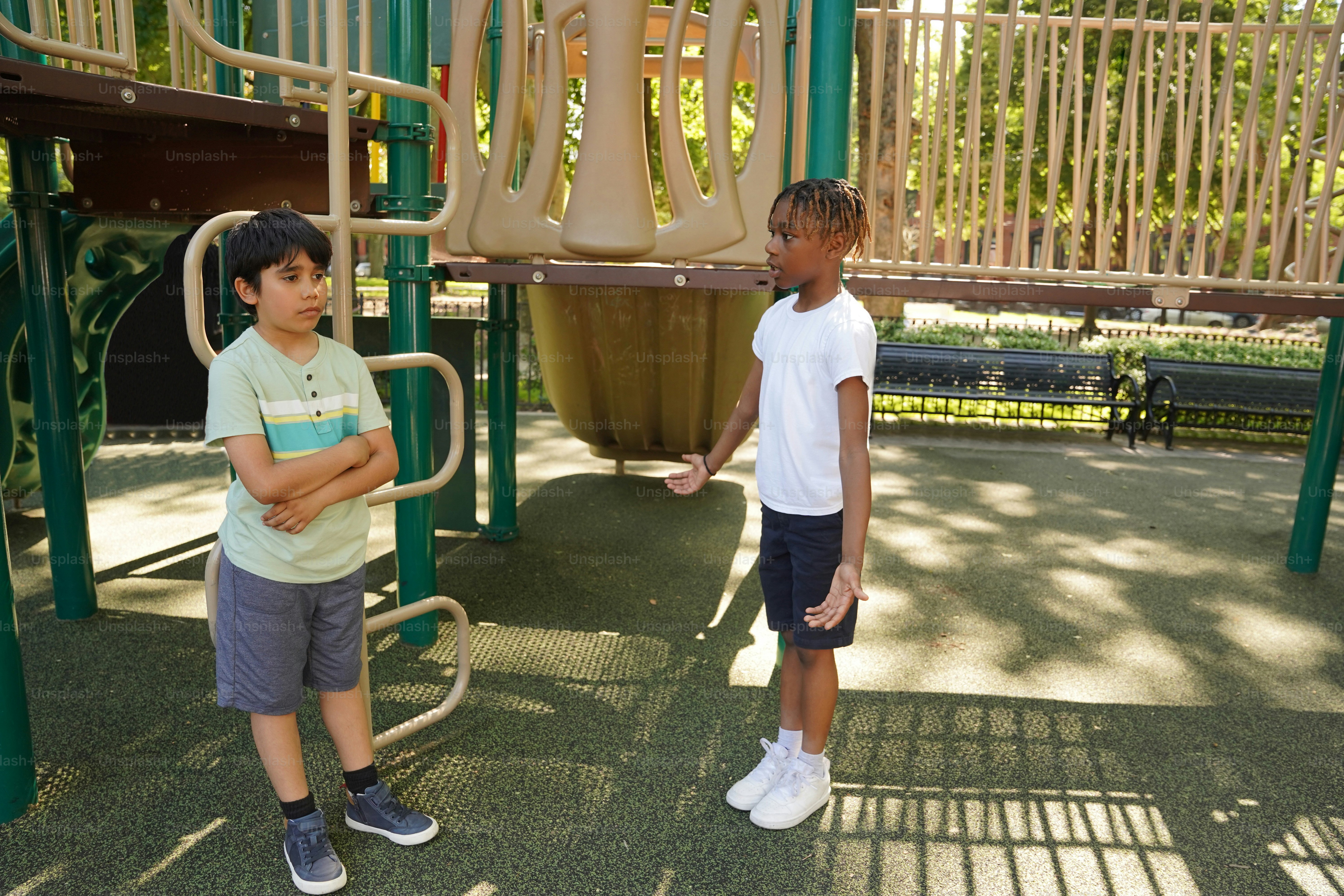 Two young boys standing in front of a playground