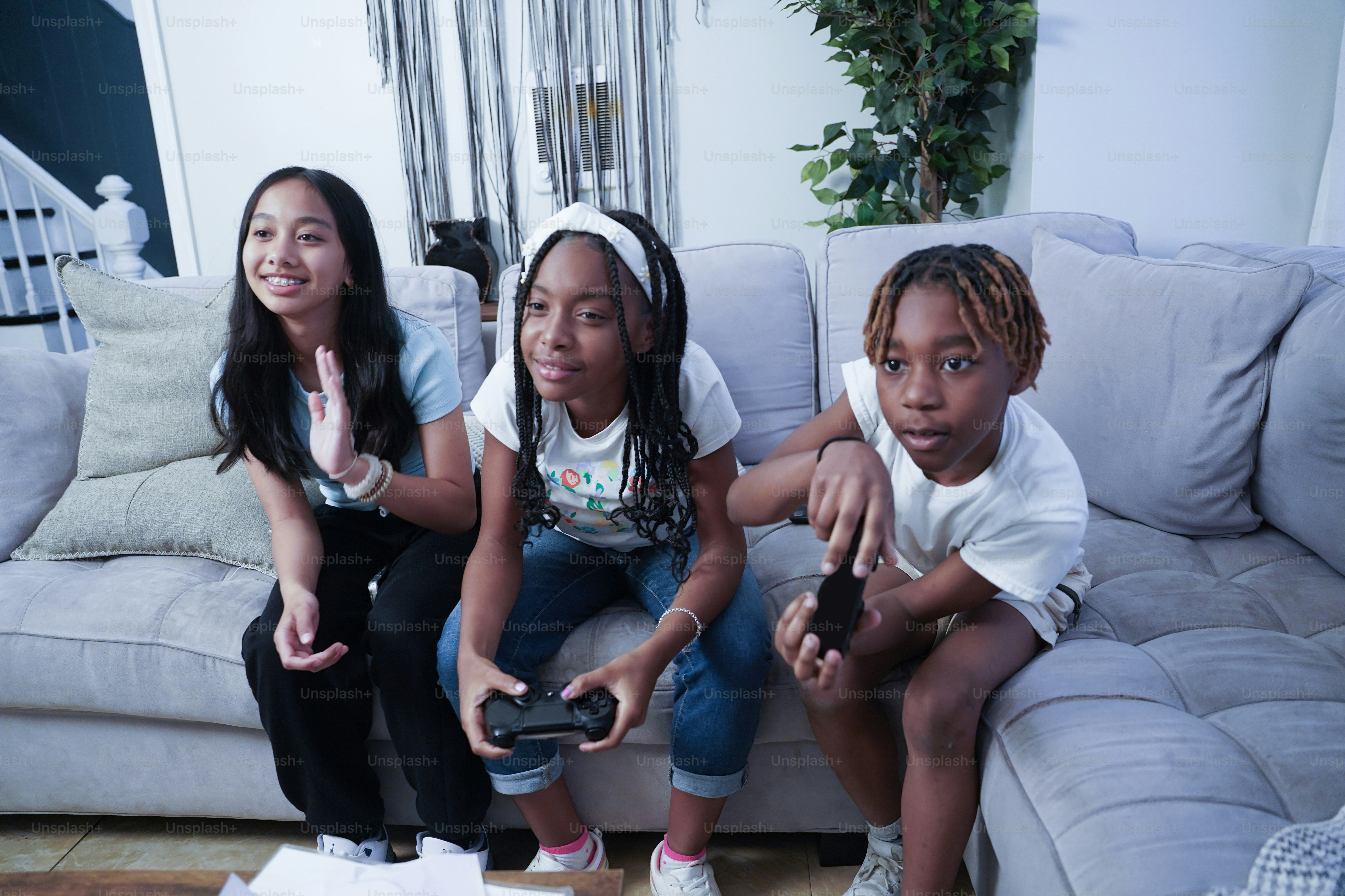 Three girls sitting on a couch playing a video game