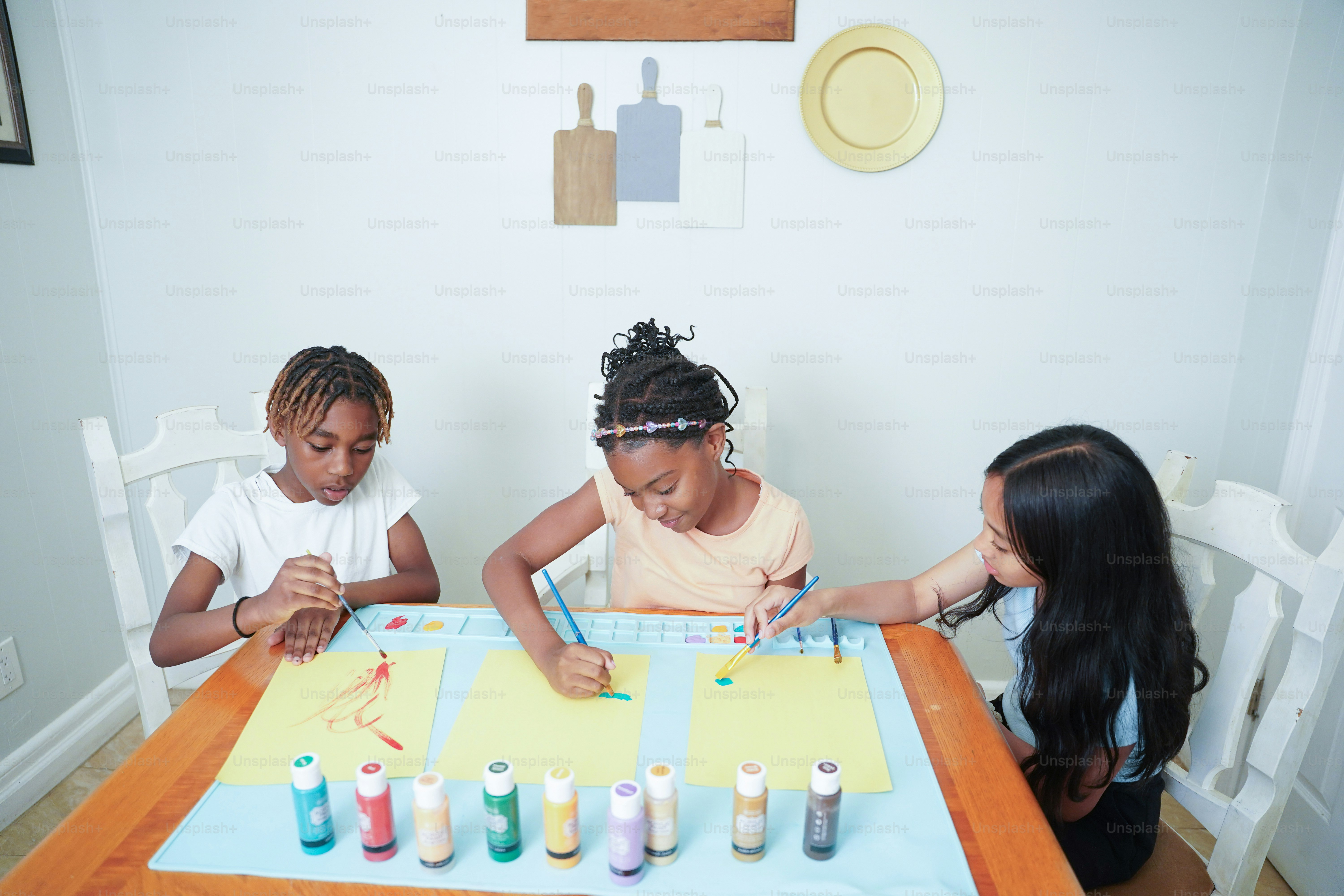 A group of children sitting at a table photo – Painting Image on Unsplash