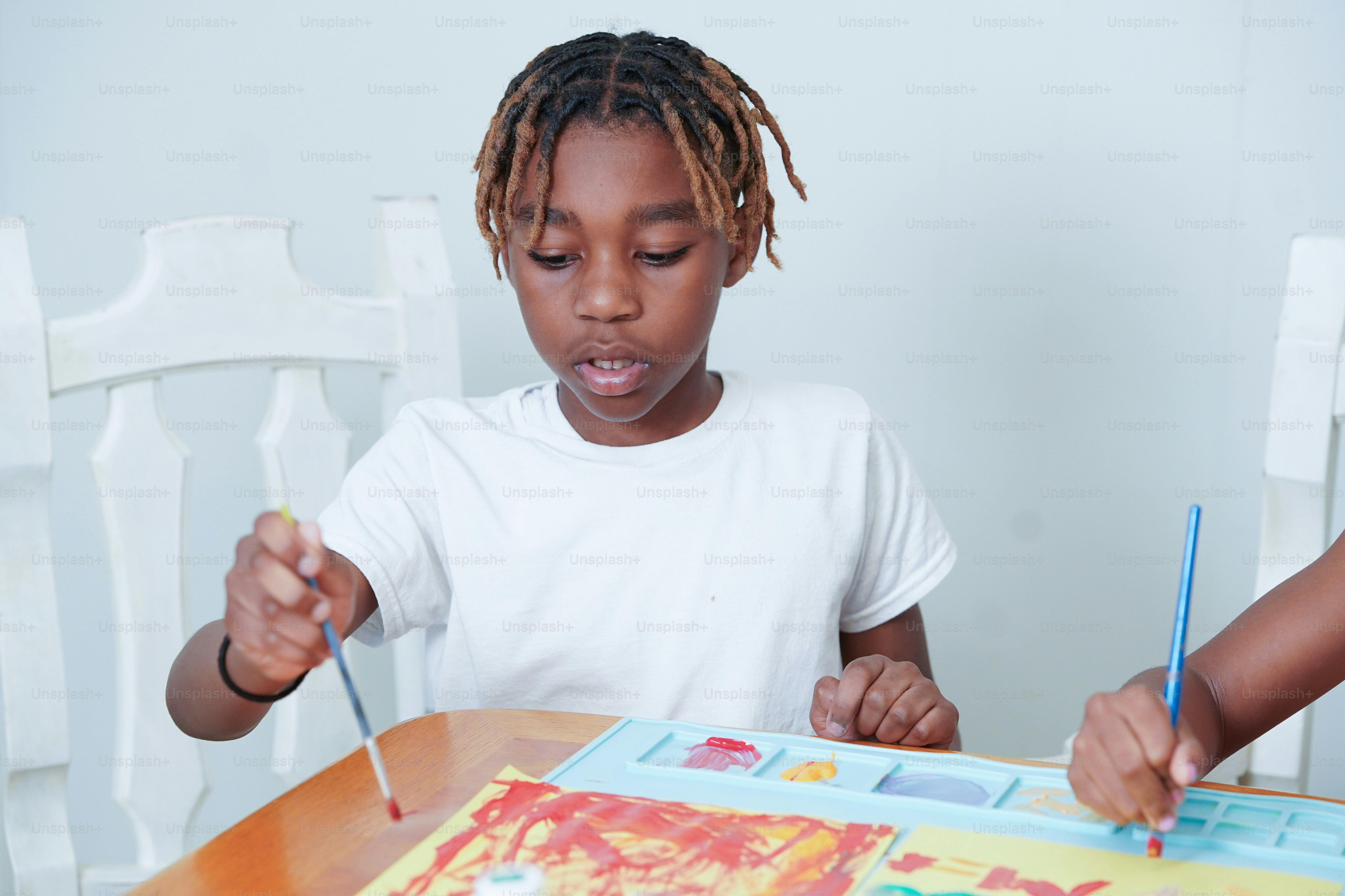 A boy and a girl sitting at a table with a cake