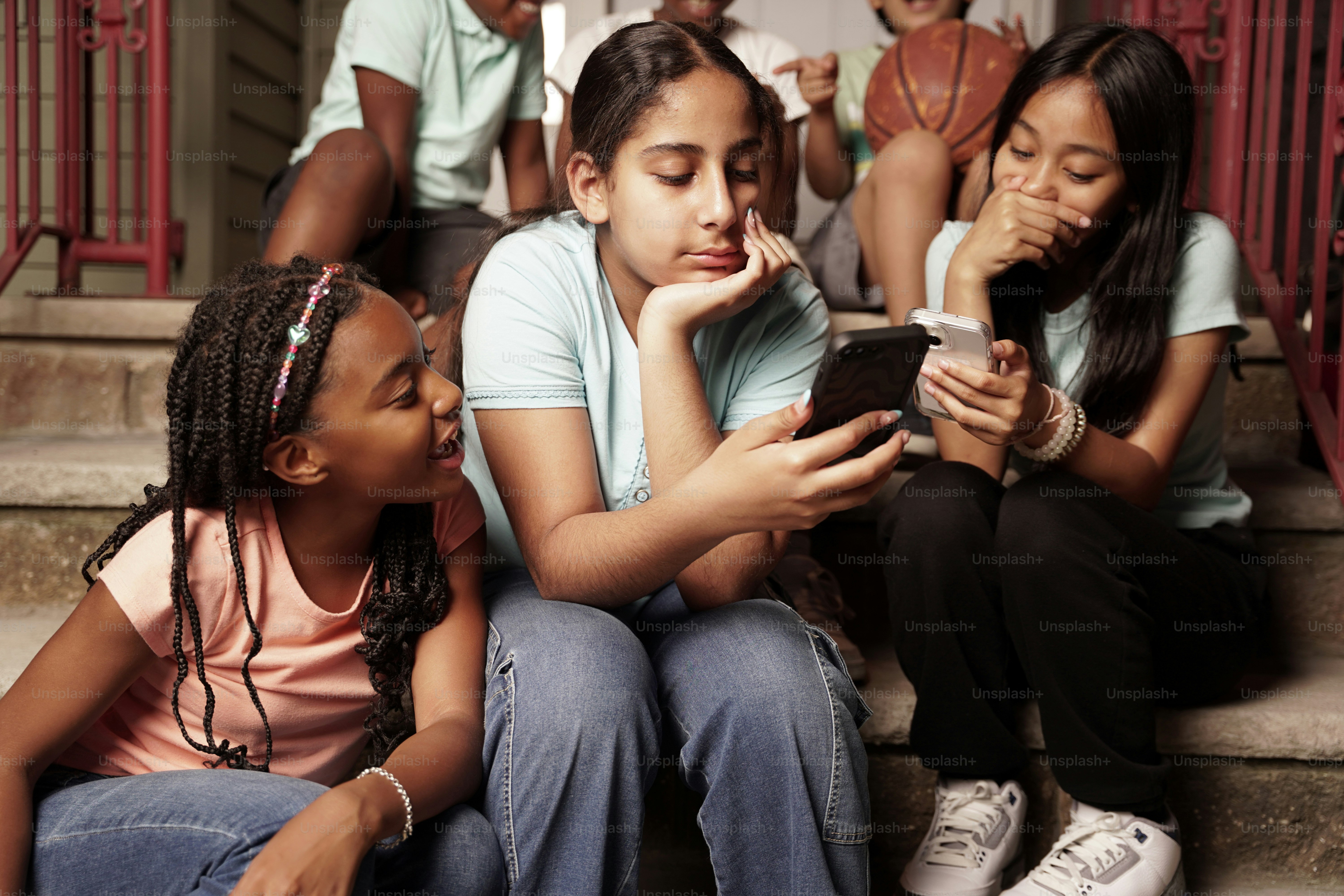 A group of children sitting on the steps of a house