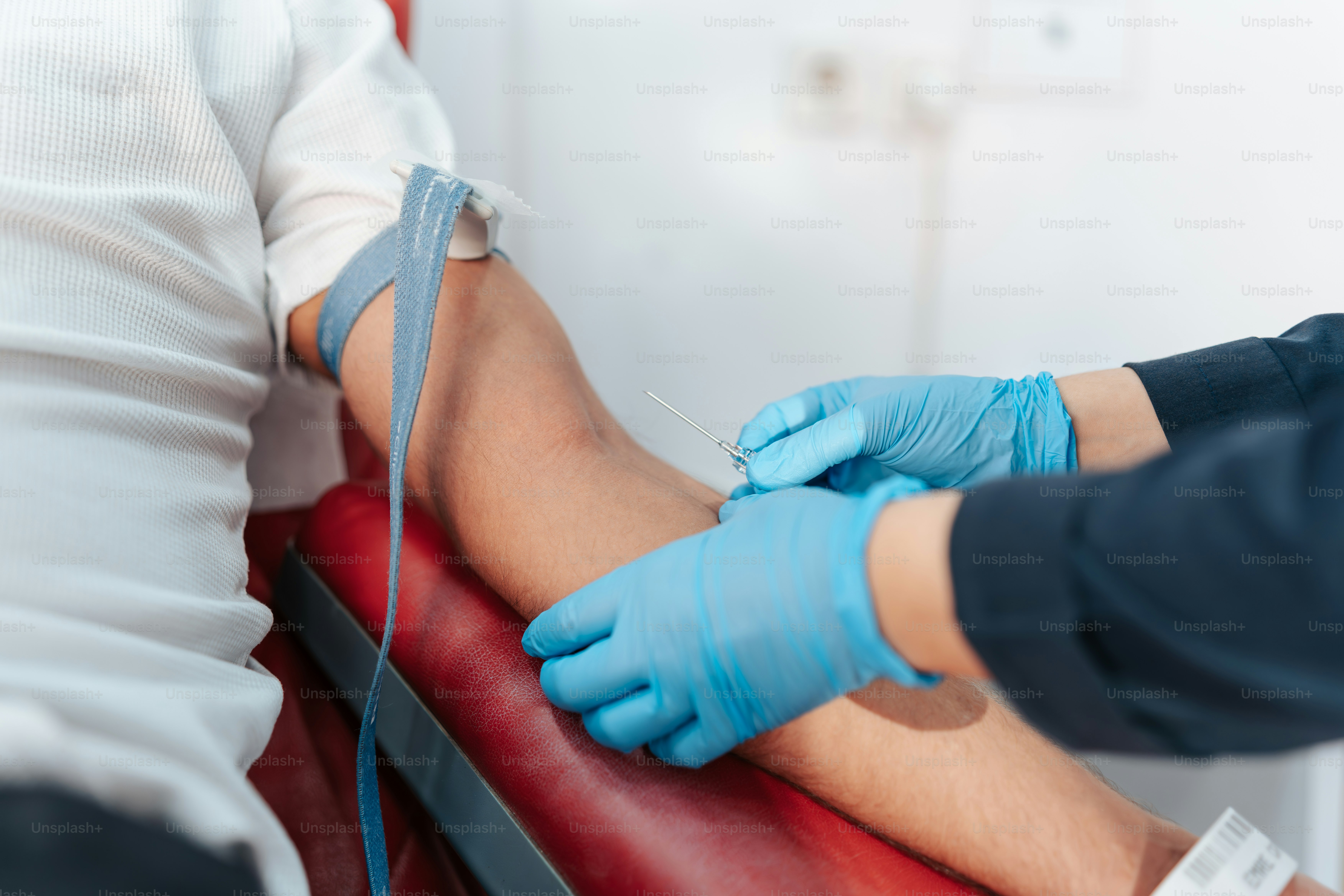 Una persona con i guanti blu è su una sedia rossa