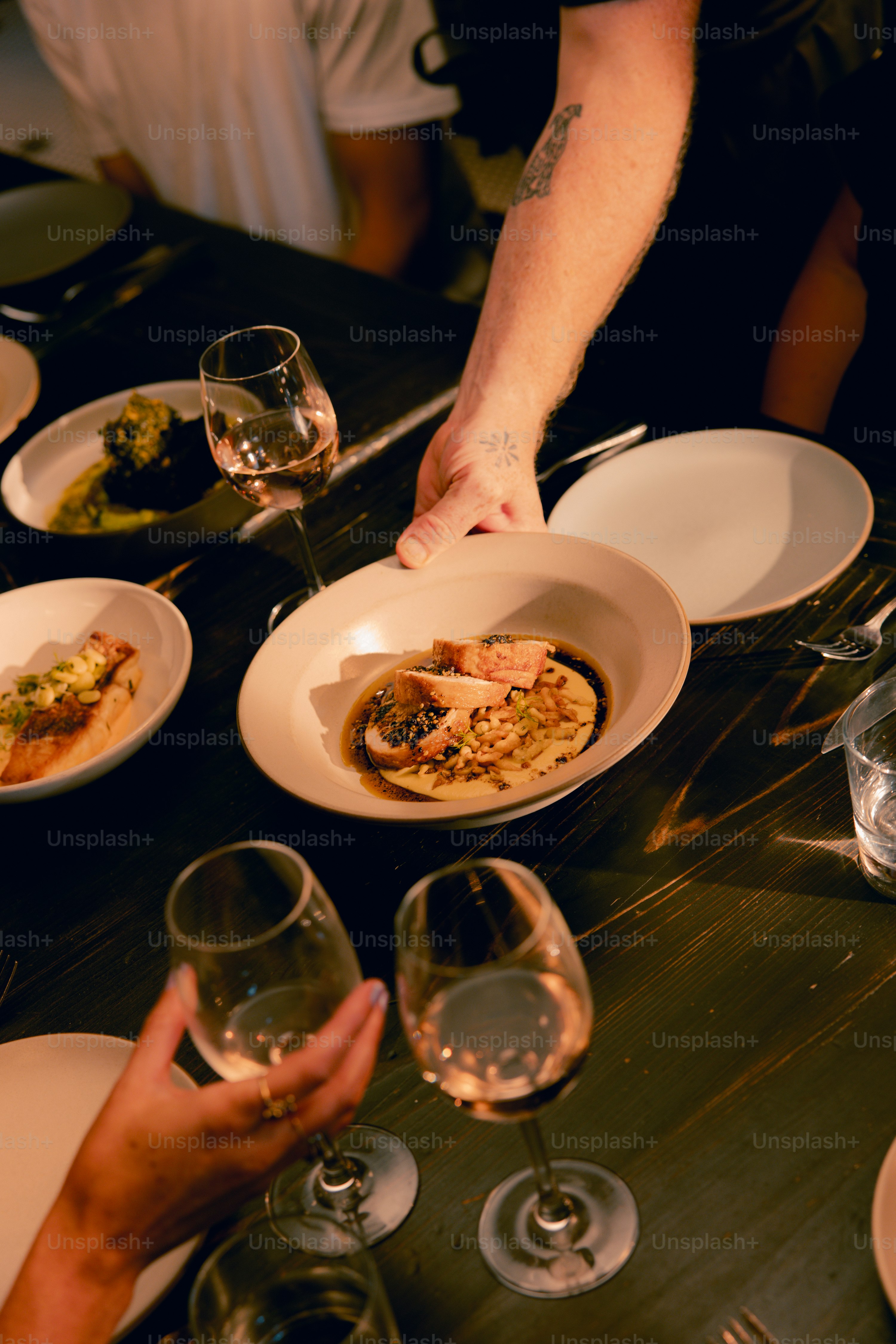 A table with plates of food and wine glasses