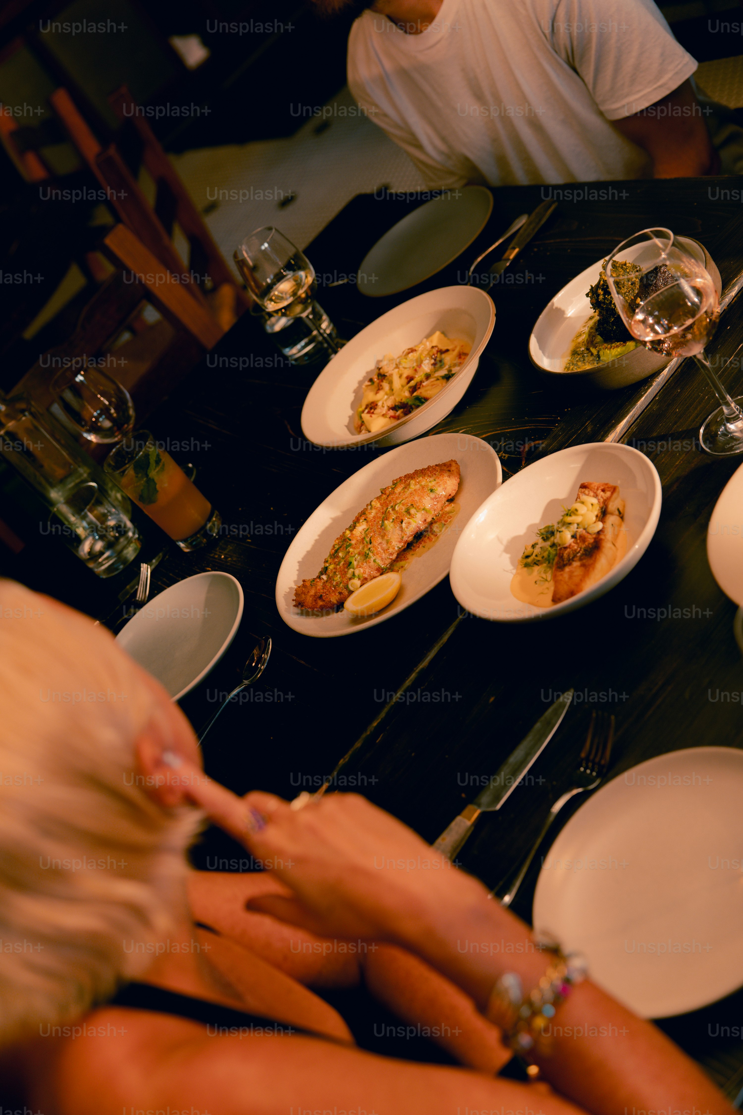 A woman sitting at a table with plates of food