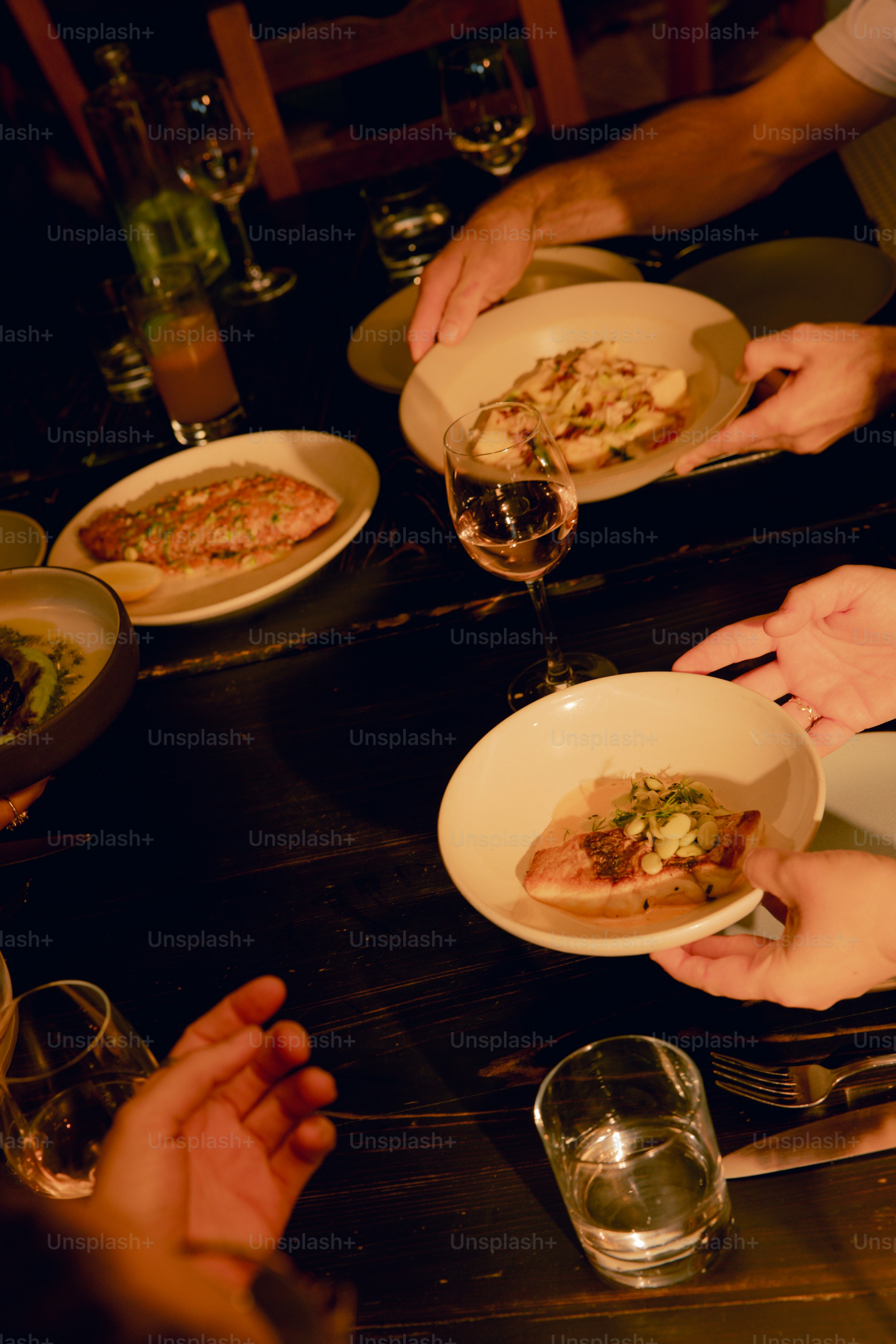 Un gruppo di persone sedute attorno a un tavolo con piatti di cibo