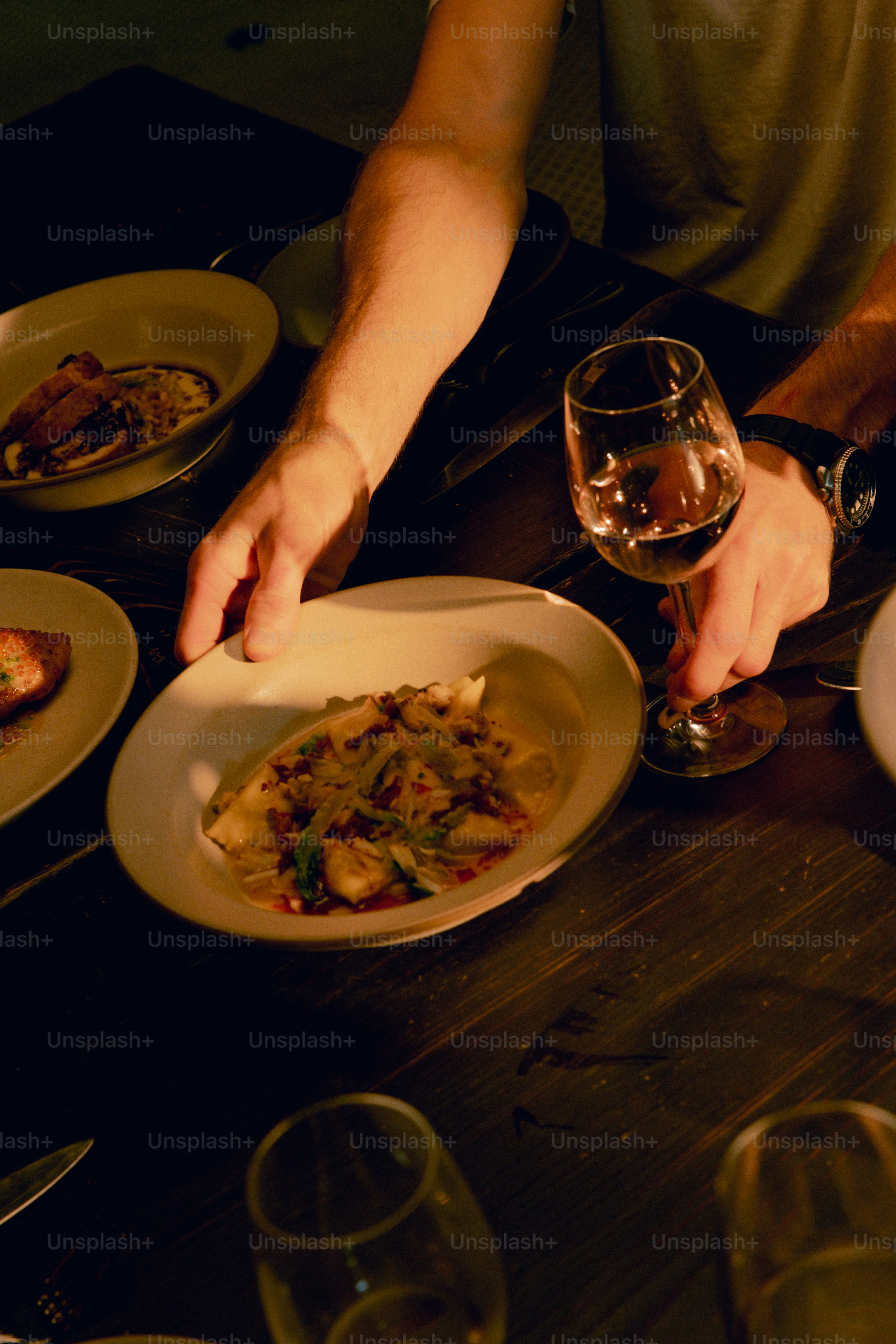 A table with plates of food and glasses of wine