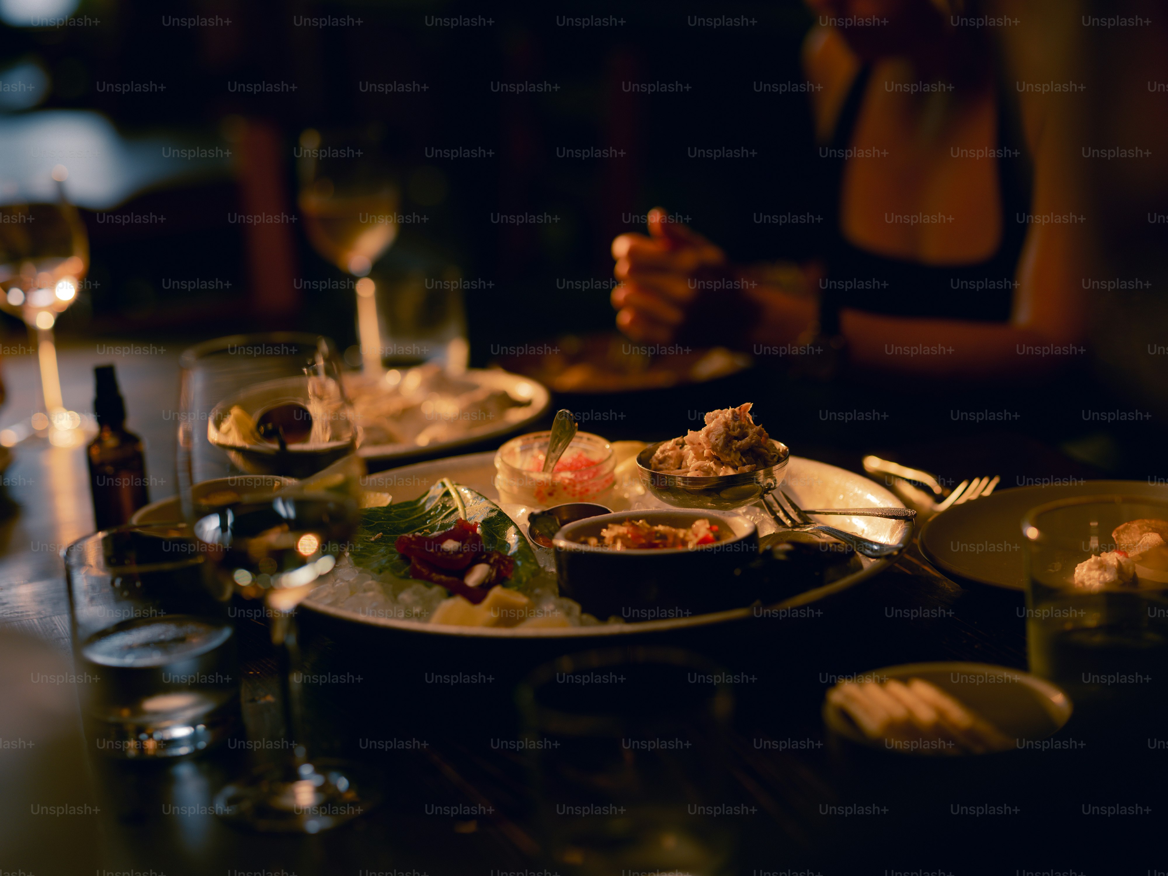 A table topped with plates of food and glasses of wine