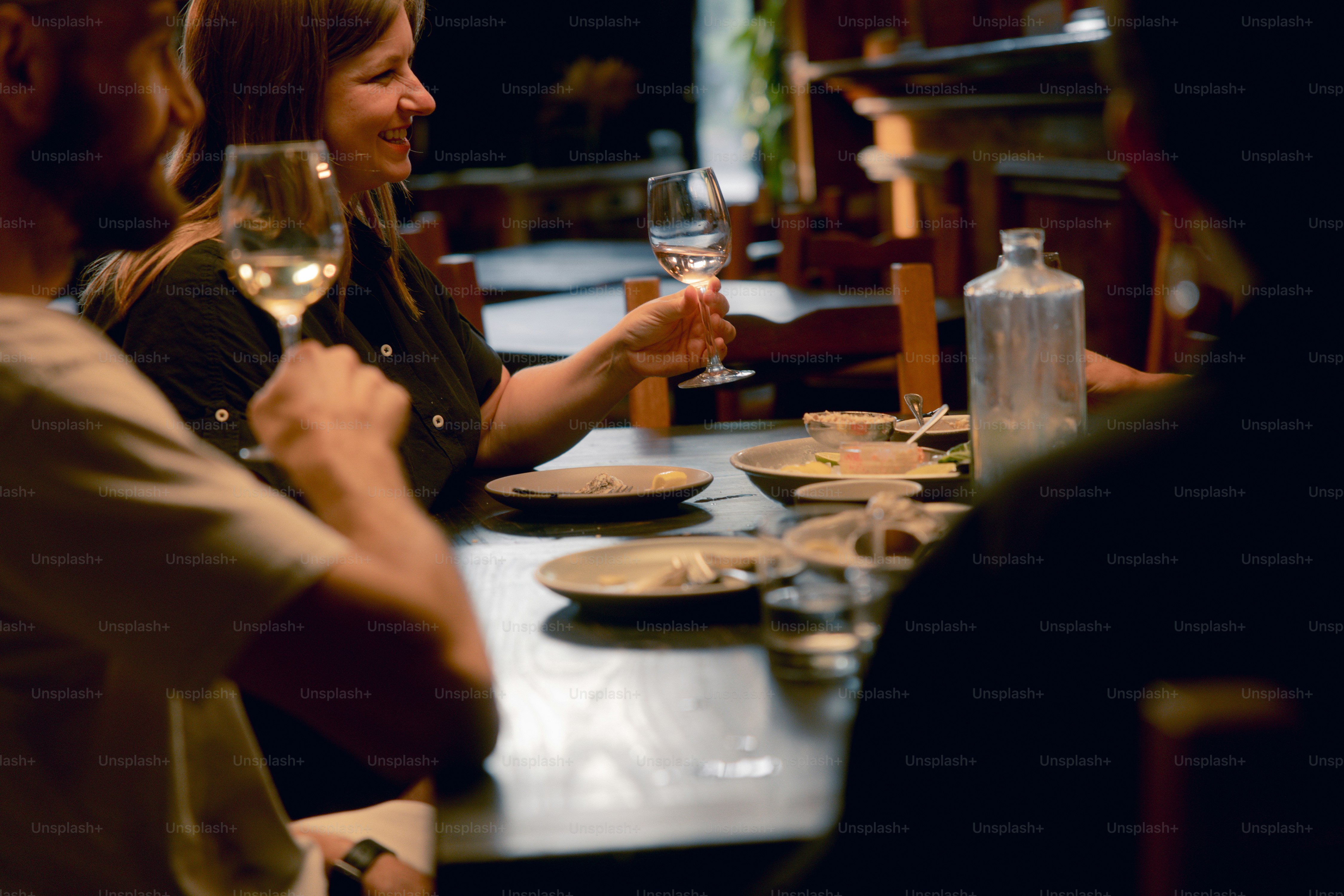 A group of people sitting around a table drinking wine
