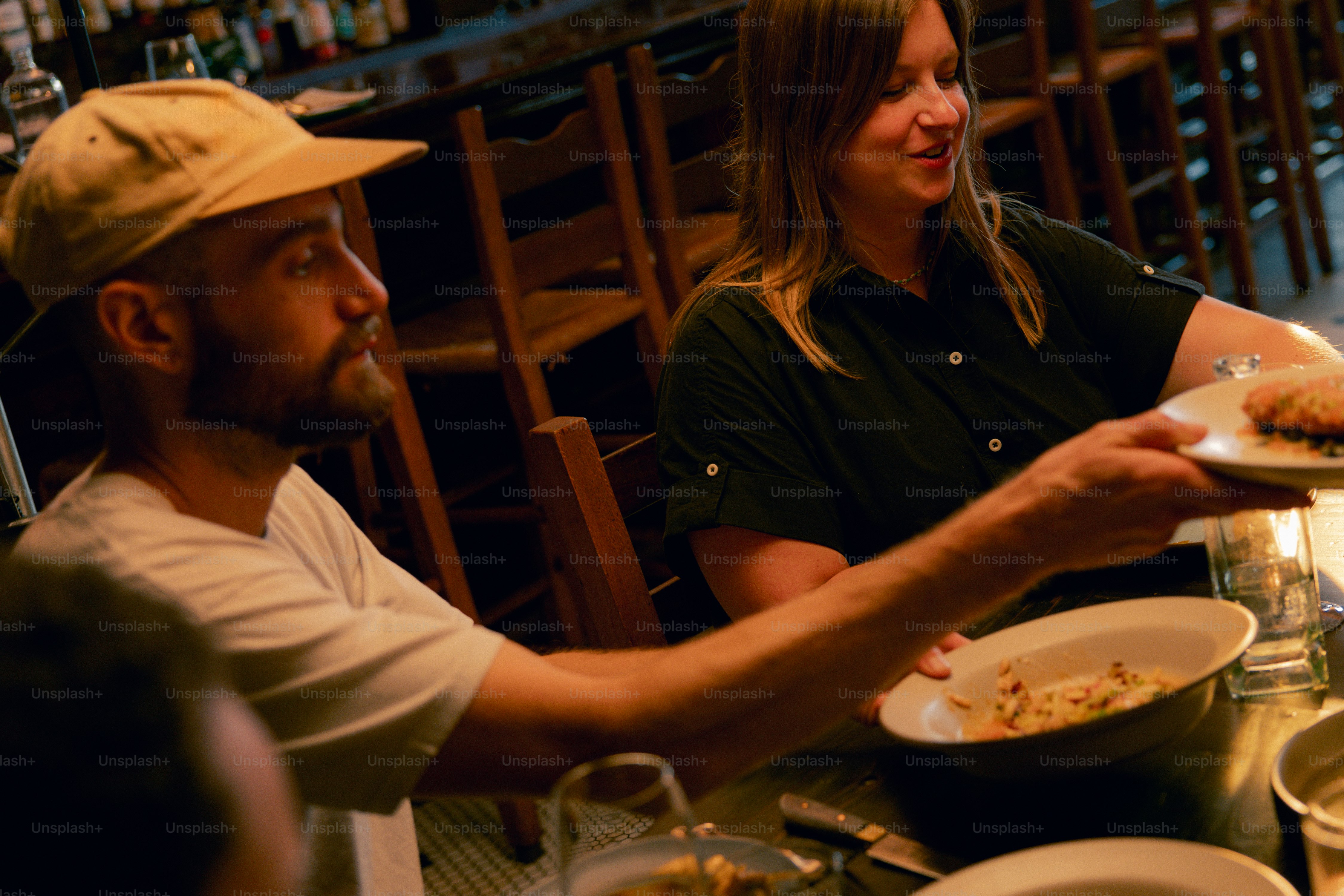 A couple of people sitting at a table with plates of food