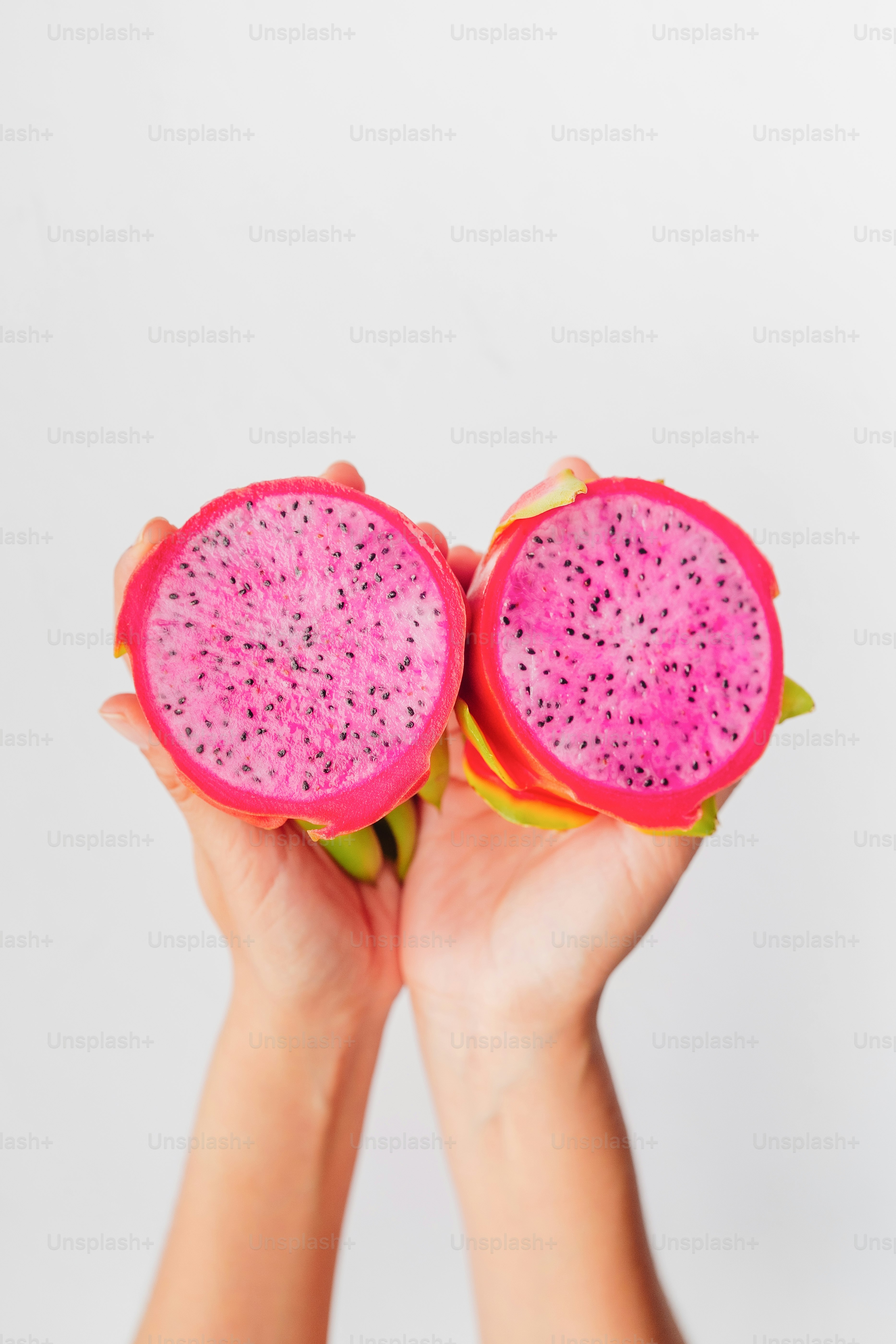 A person holding two pieces of fruit in their hands
