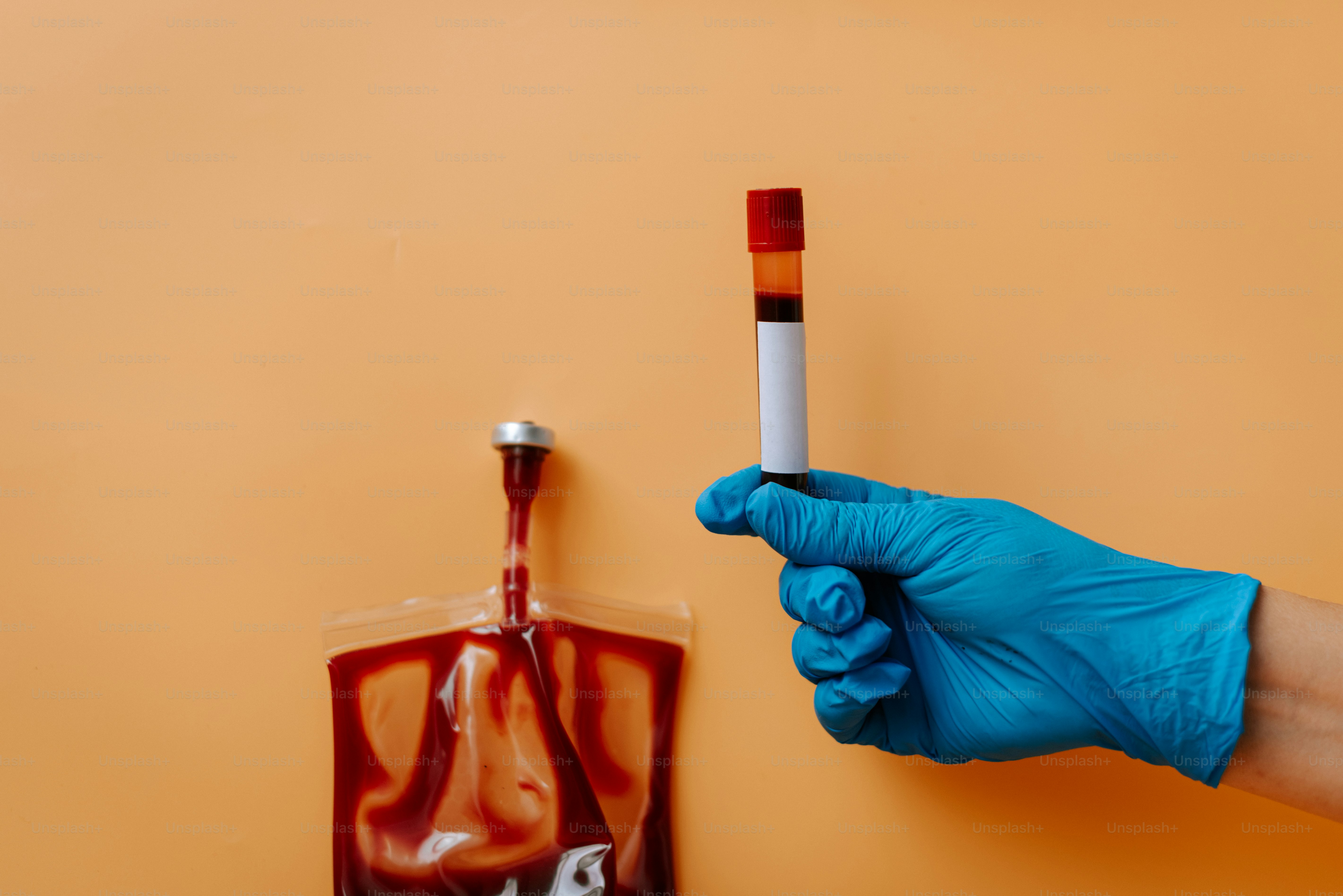 A hand in blue gloves holding a cigarette in front of a bag of cigarettes