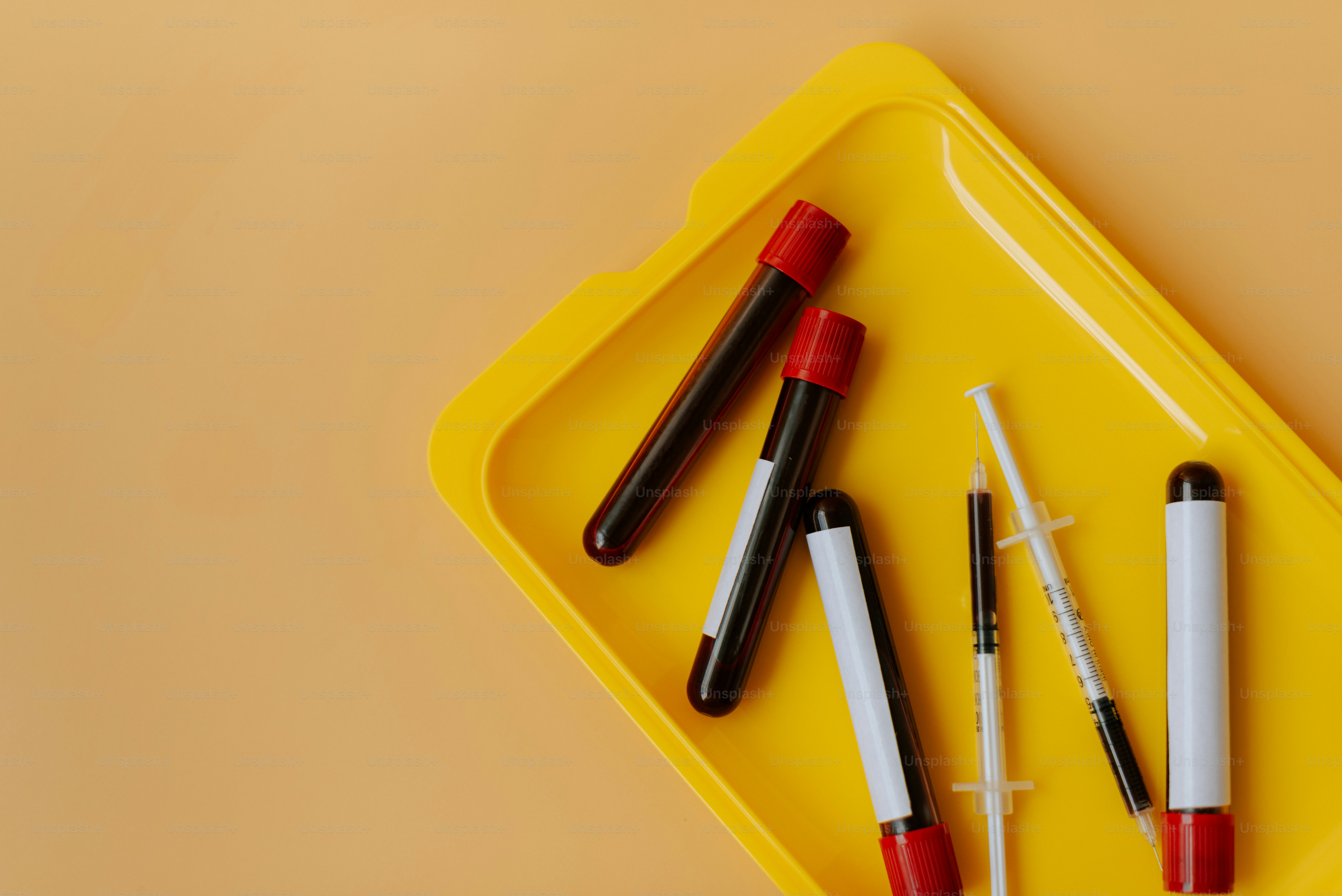 Ein gelbes Tablett mit vier Stiften und einem Stifthalter