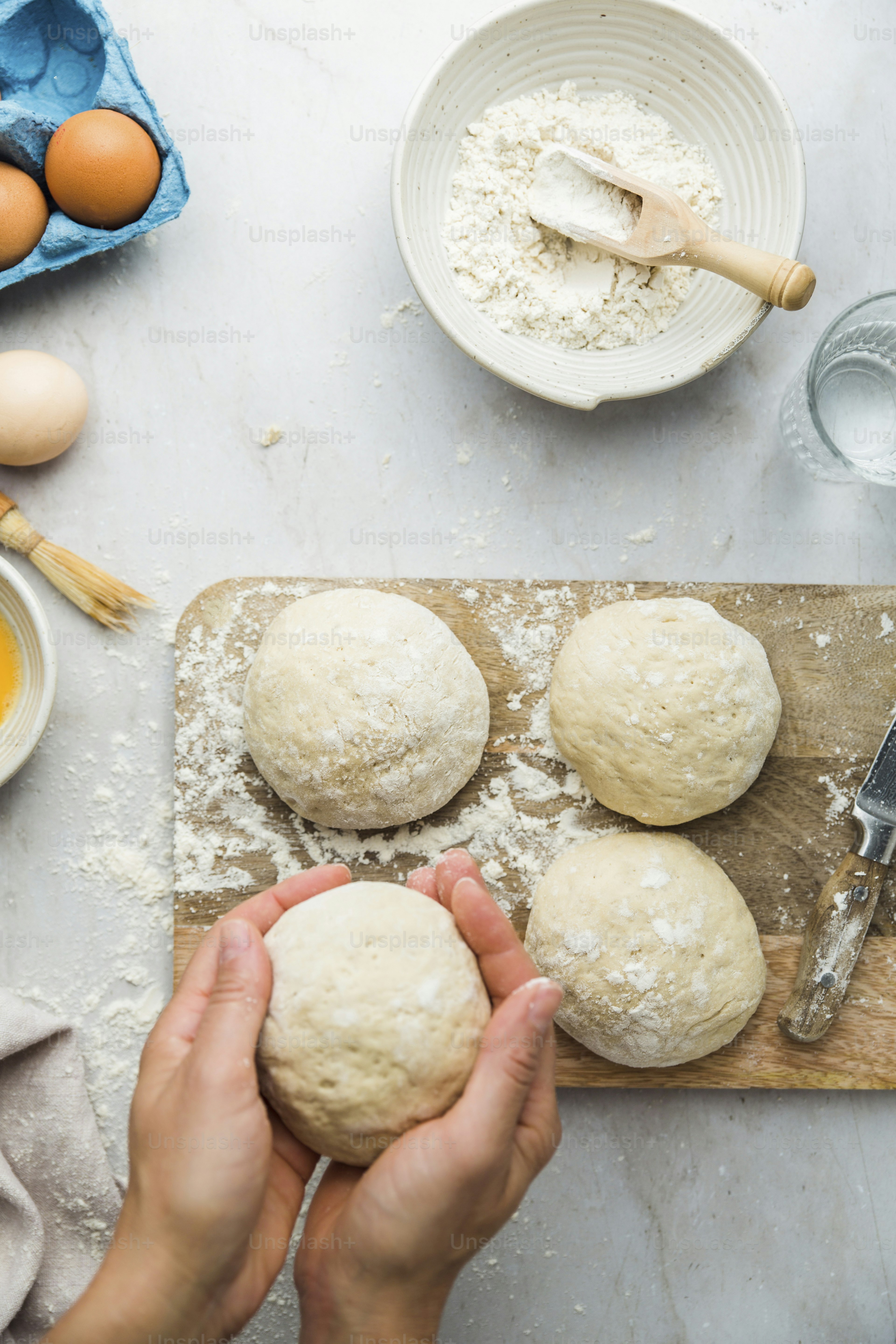 A person is kneading dough on a cutting board