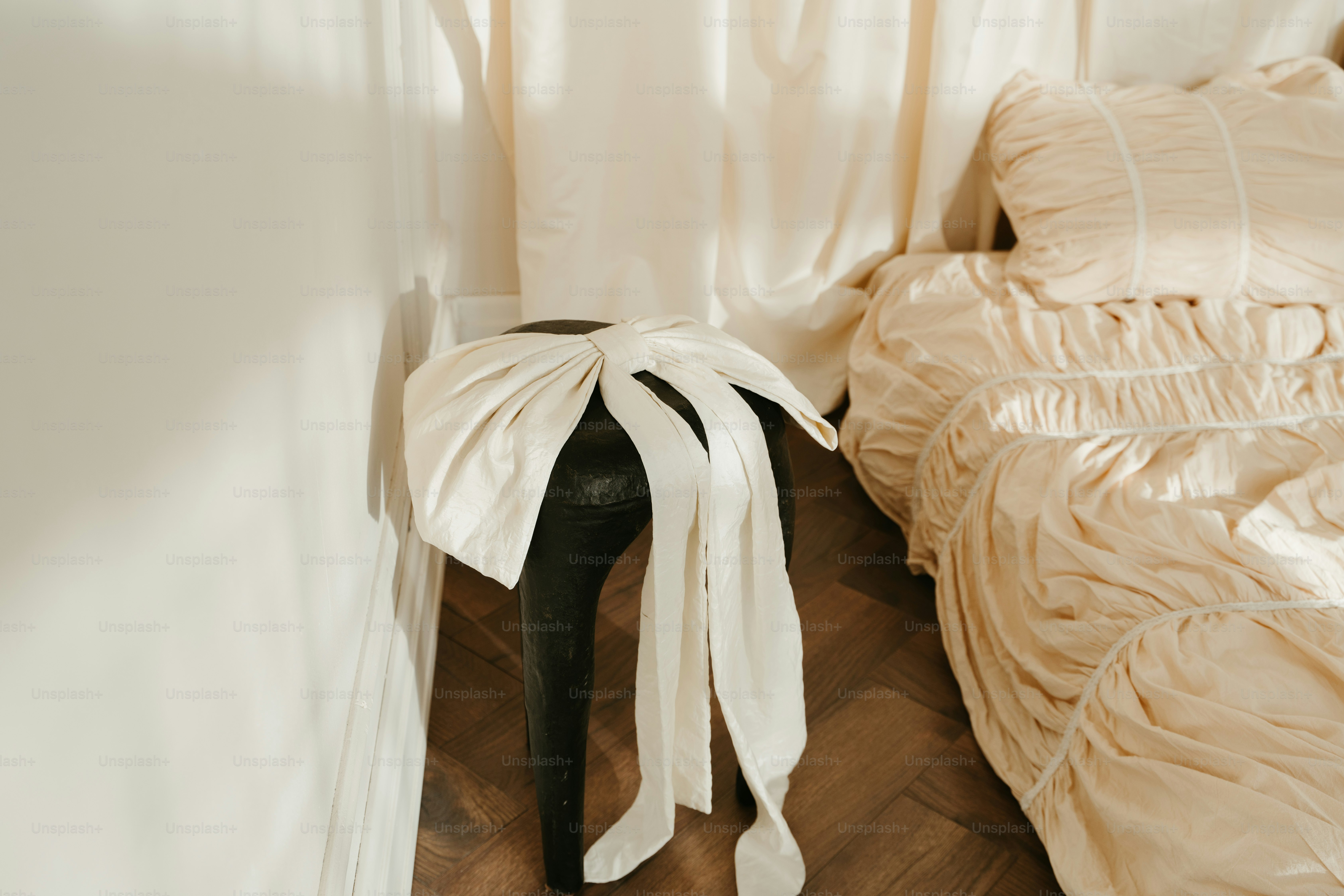 A white bed sitting next to a white curtain
