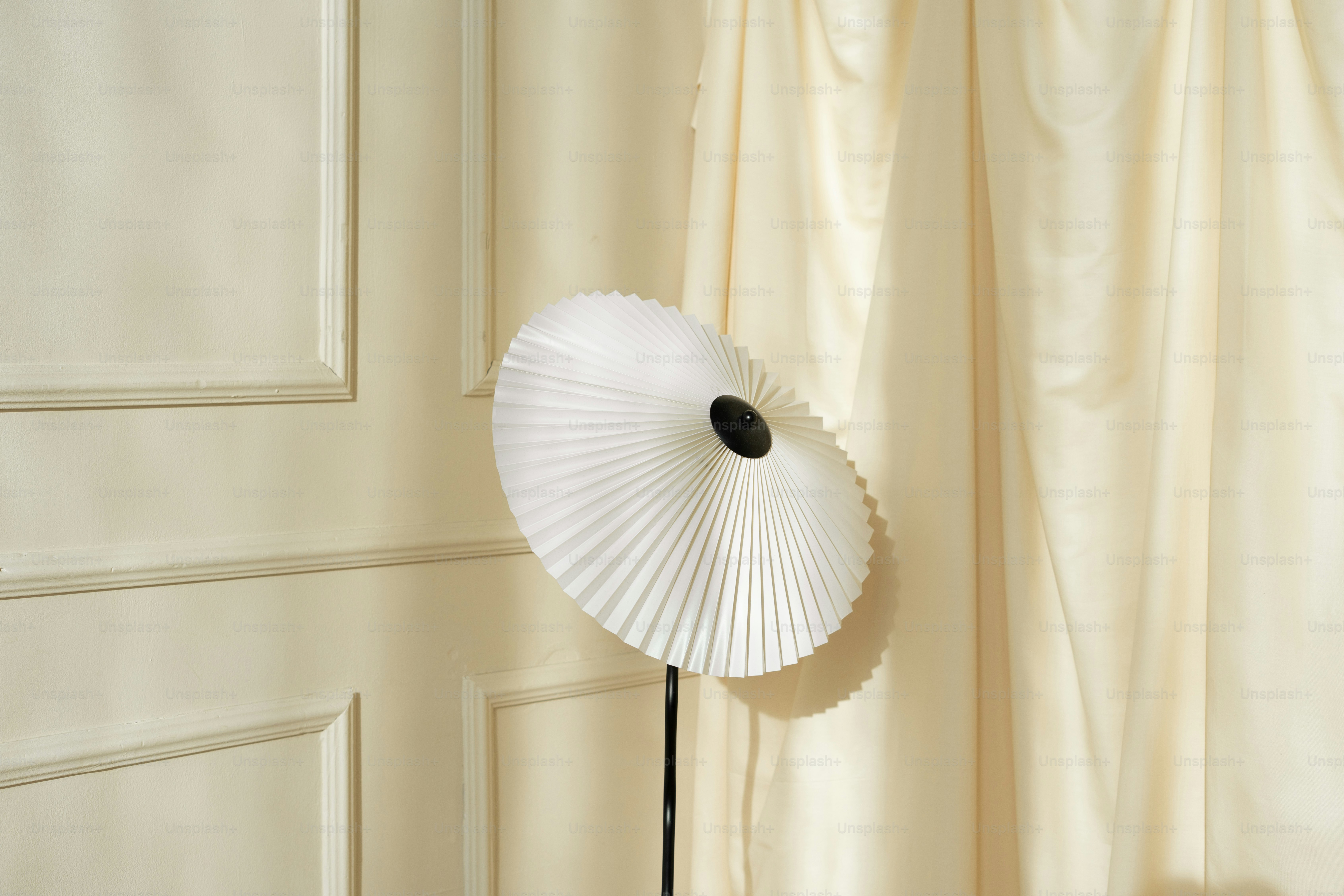 A white fan sitting on top of a table next to a window