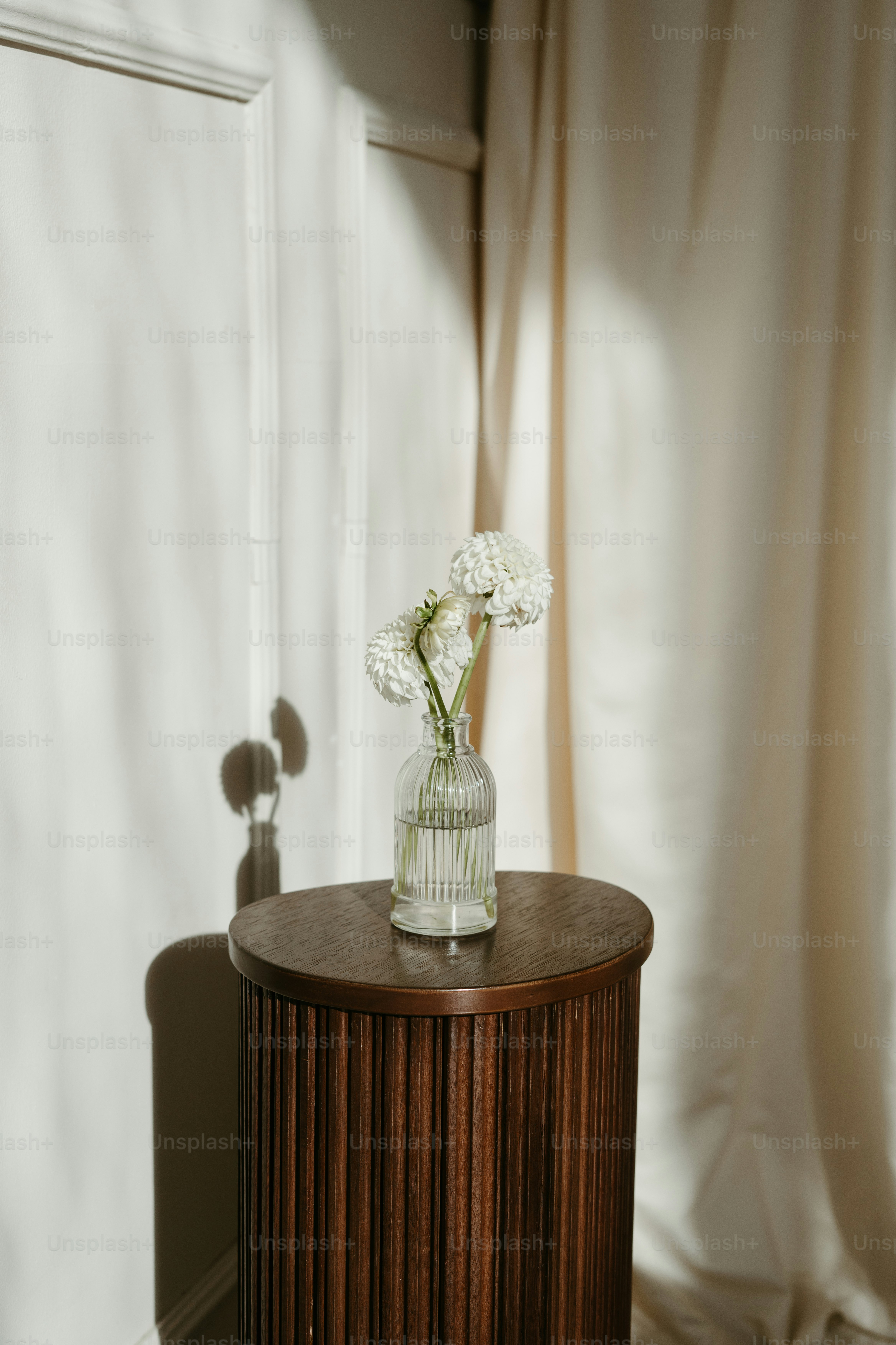 A wooden table with a vase of flowers on top of it