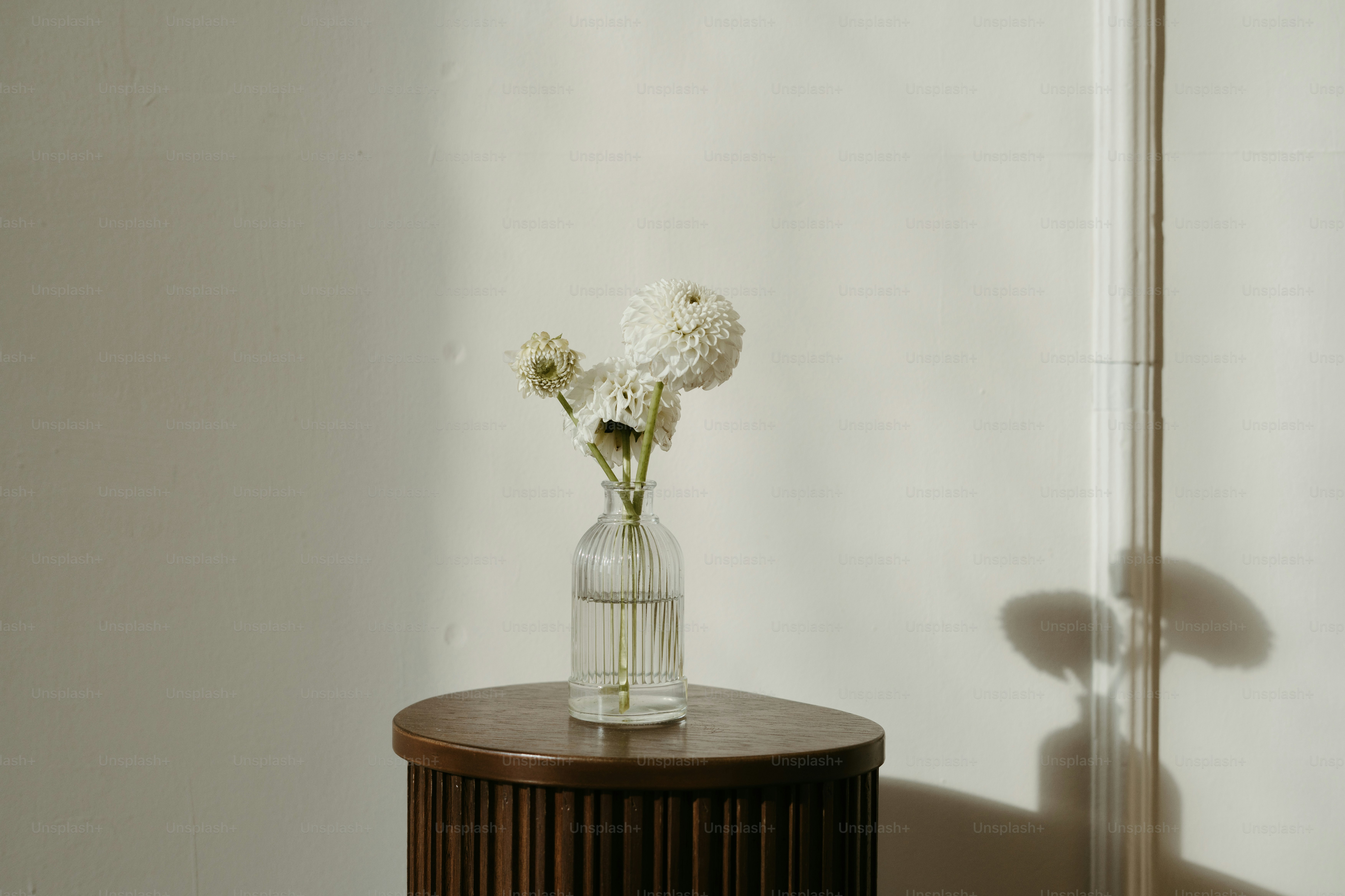 A wooden table with a vase of flowers on top of it photo – Interior ...