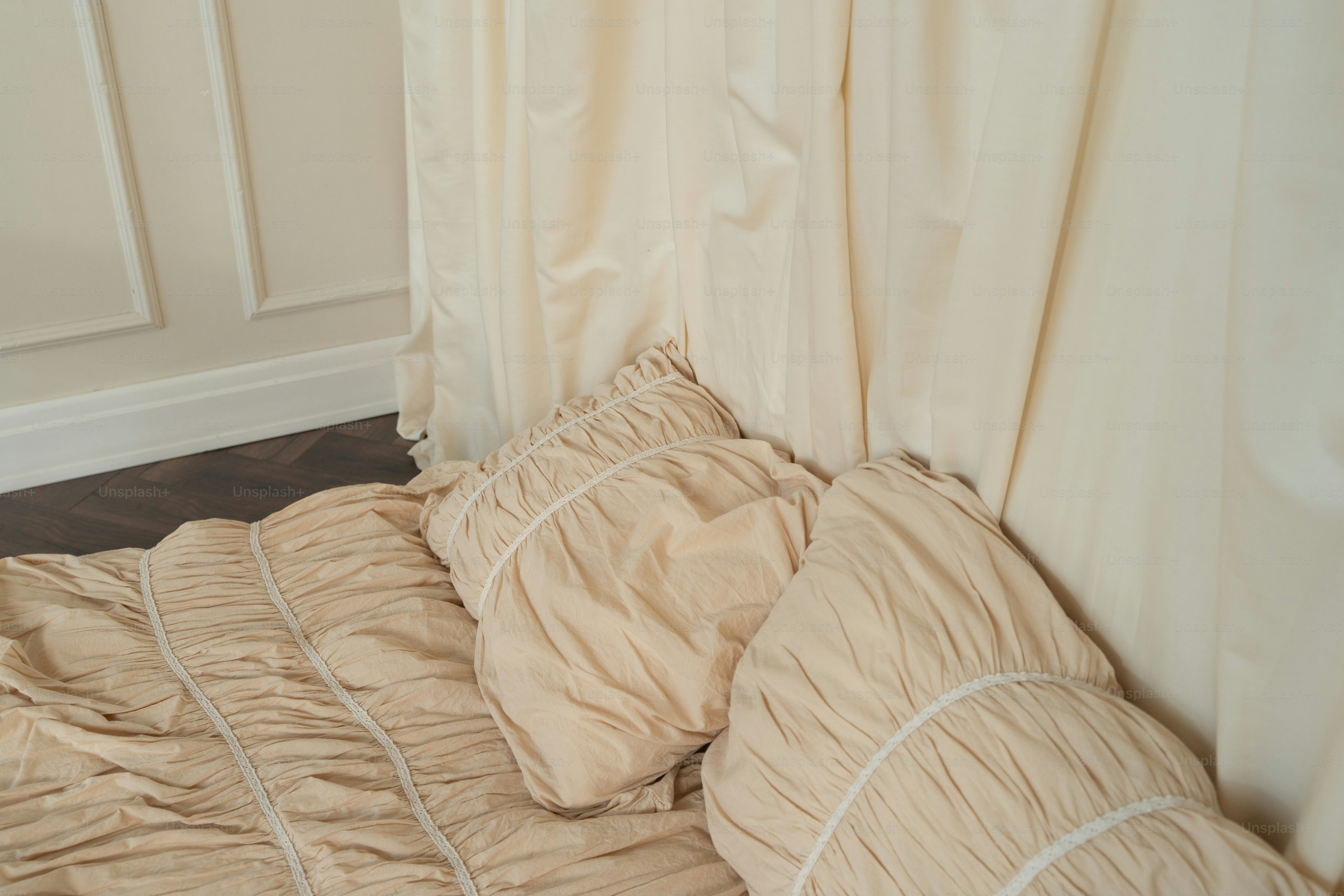 An unmade bed with a beige comforter on top of it