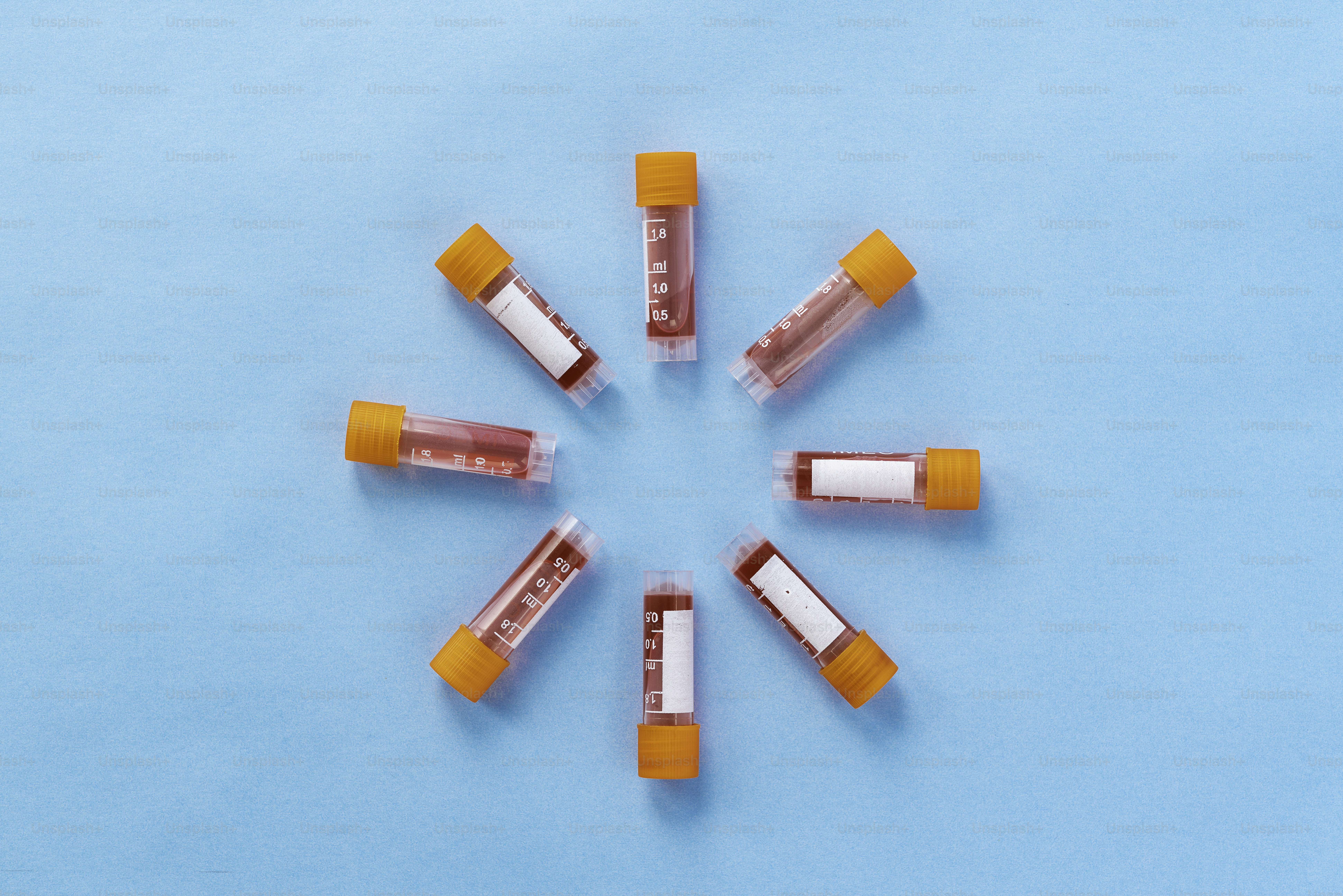 Un gruppo di pillole arancioni e bianche su una superficie blu