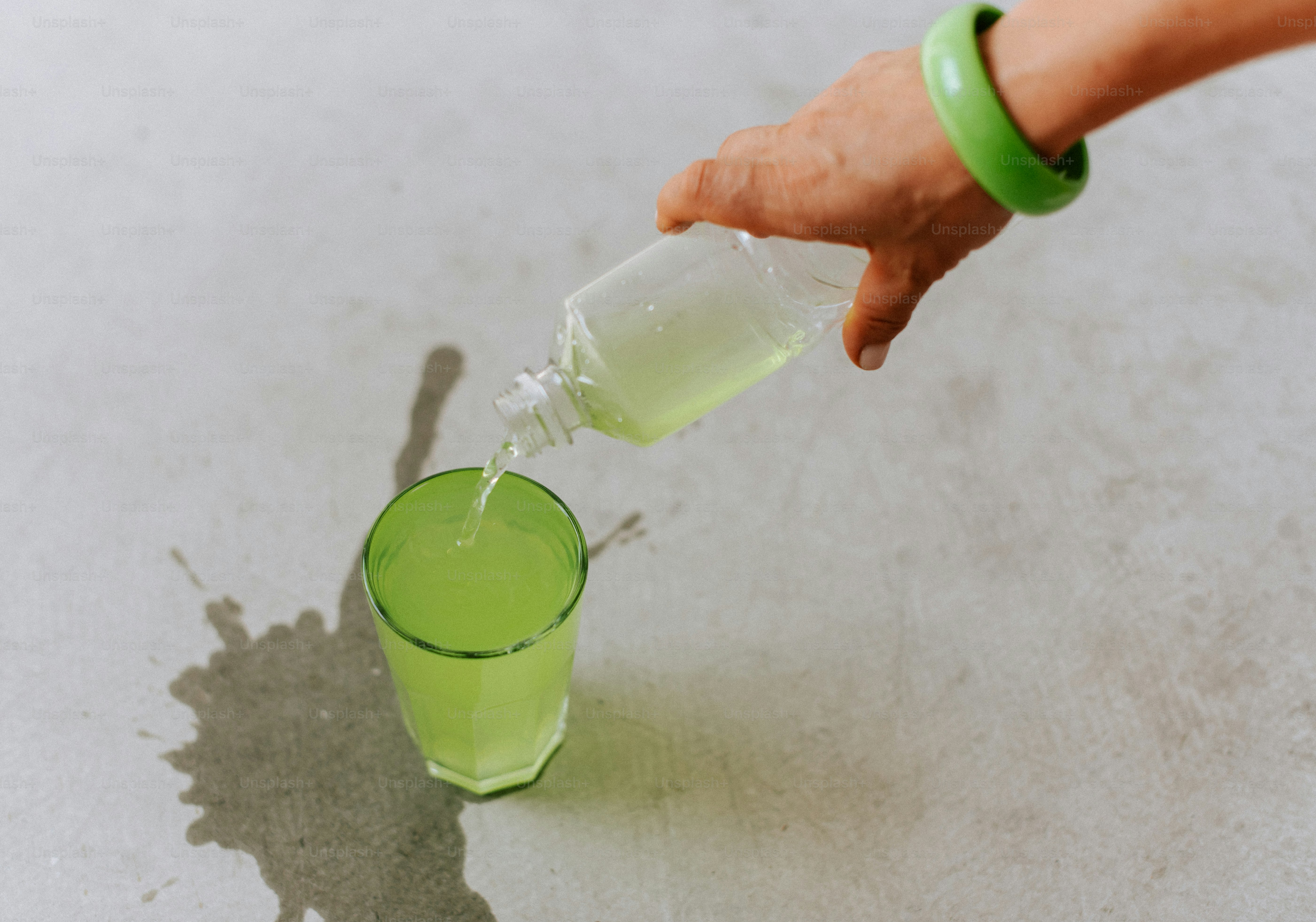 A person is pouring a drink into a glass