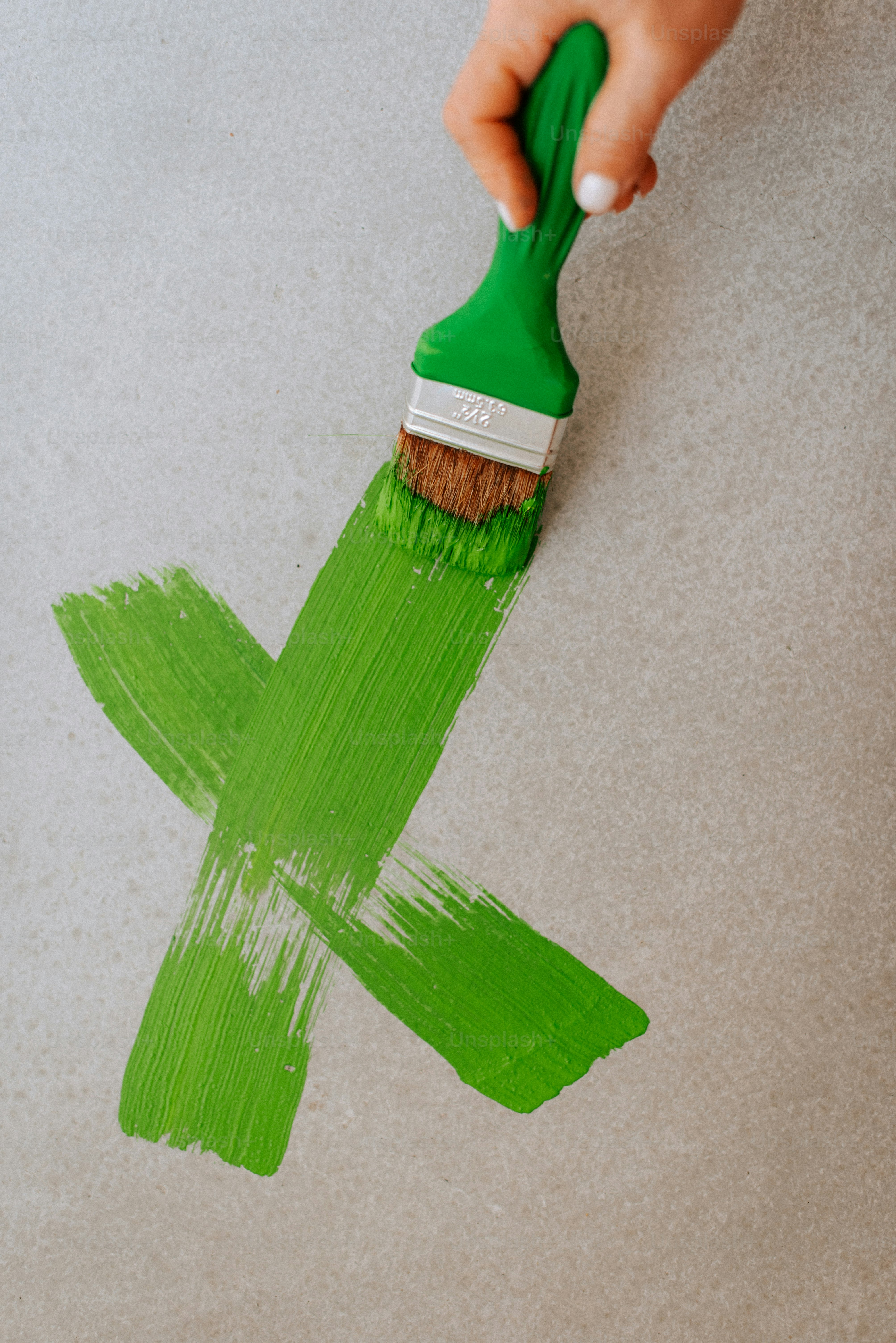 A person using a paint brush to paint a wall