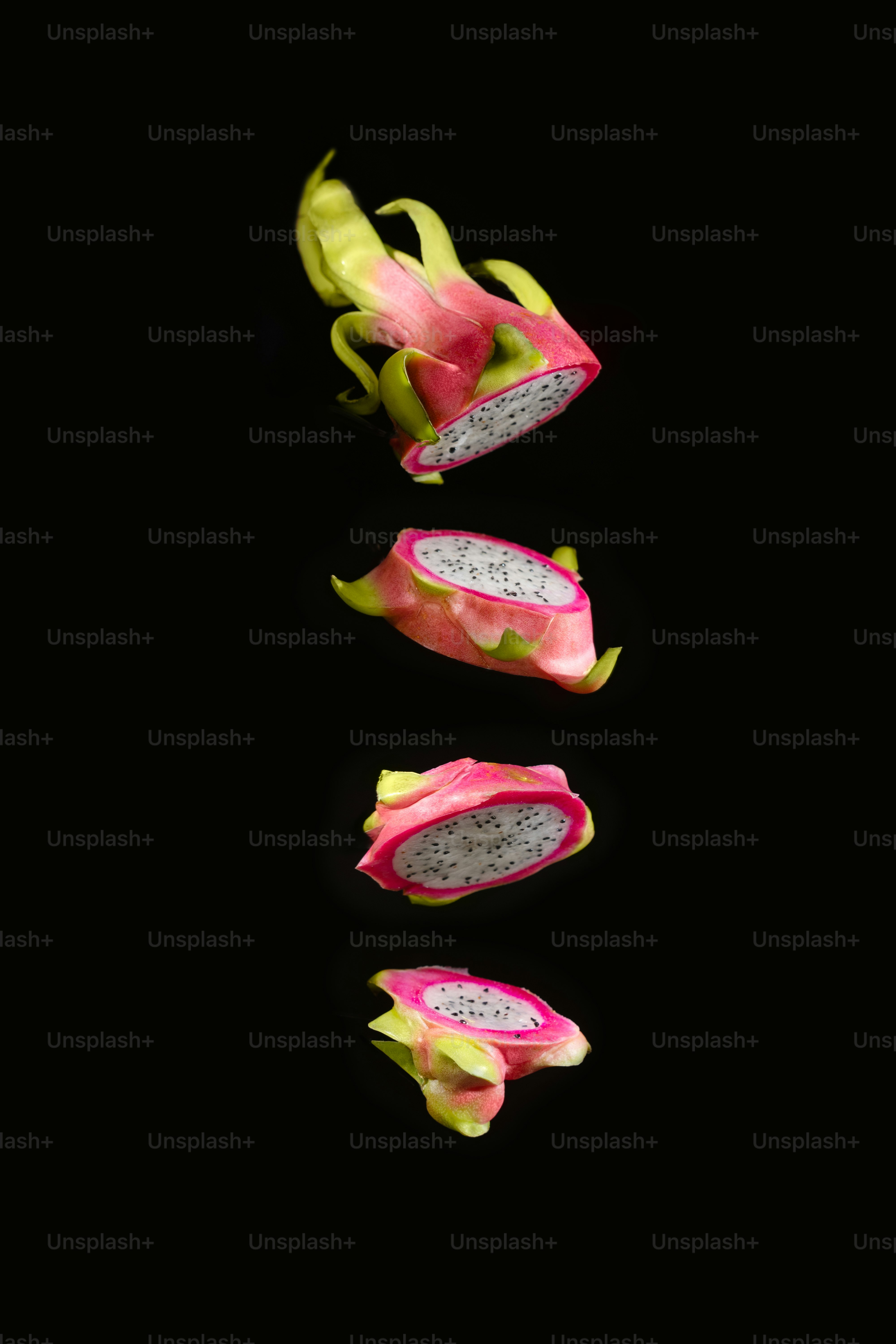 A dragon fruit cut in half on a black background
