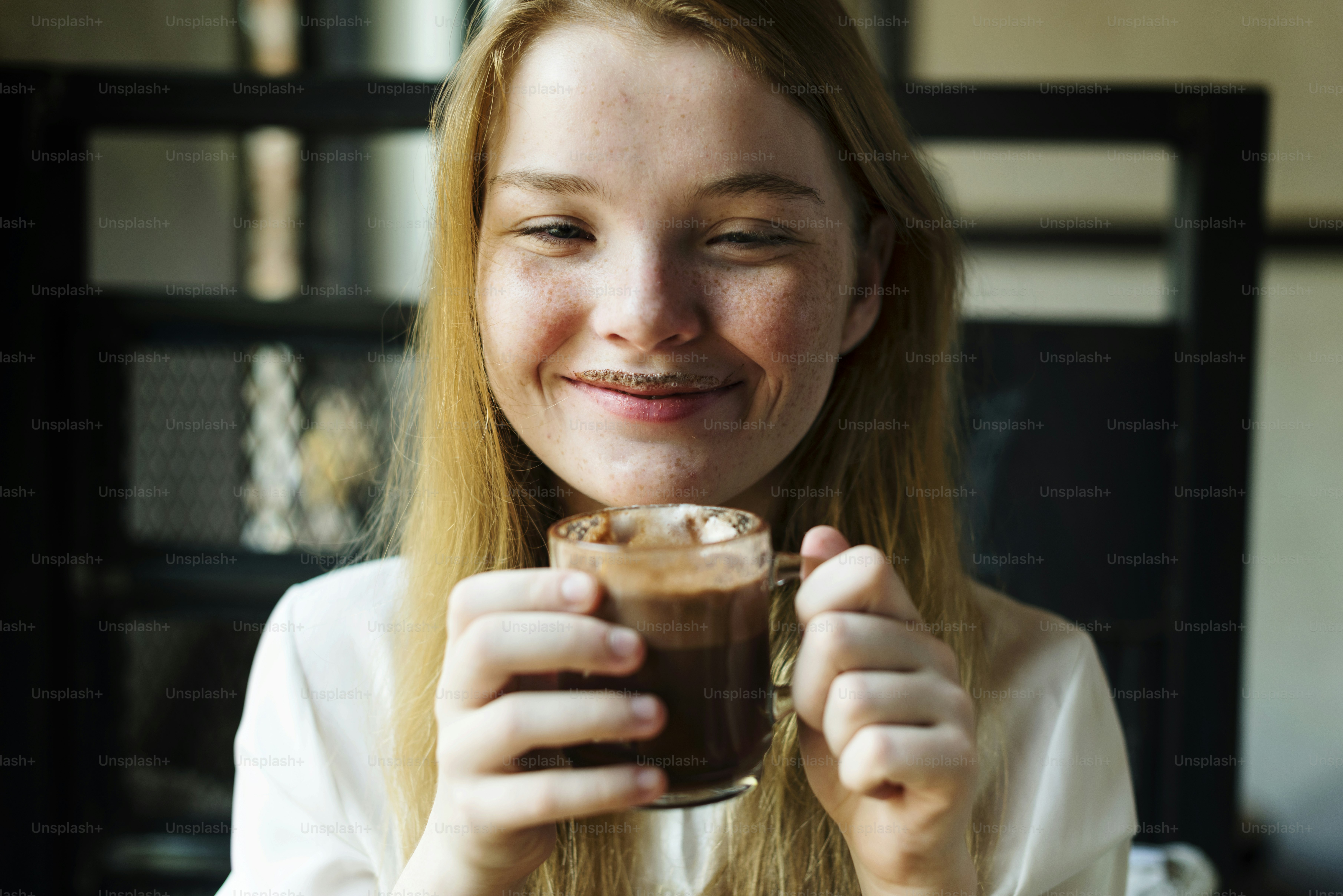 La giovane donna beve il concetto gustoso della cioccolata calda