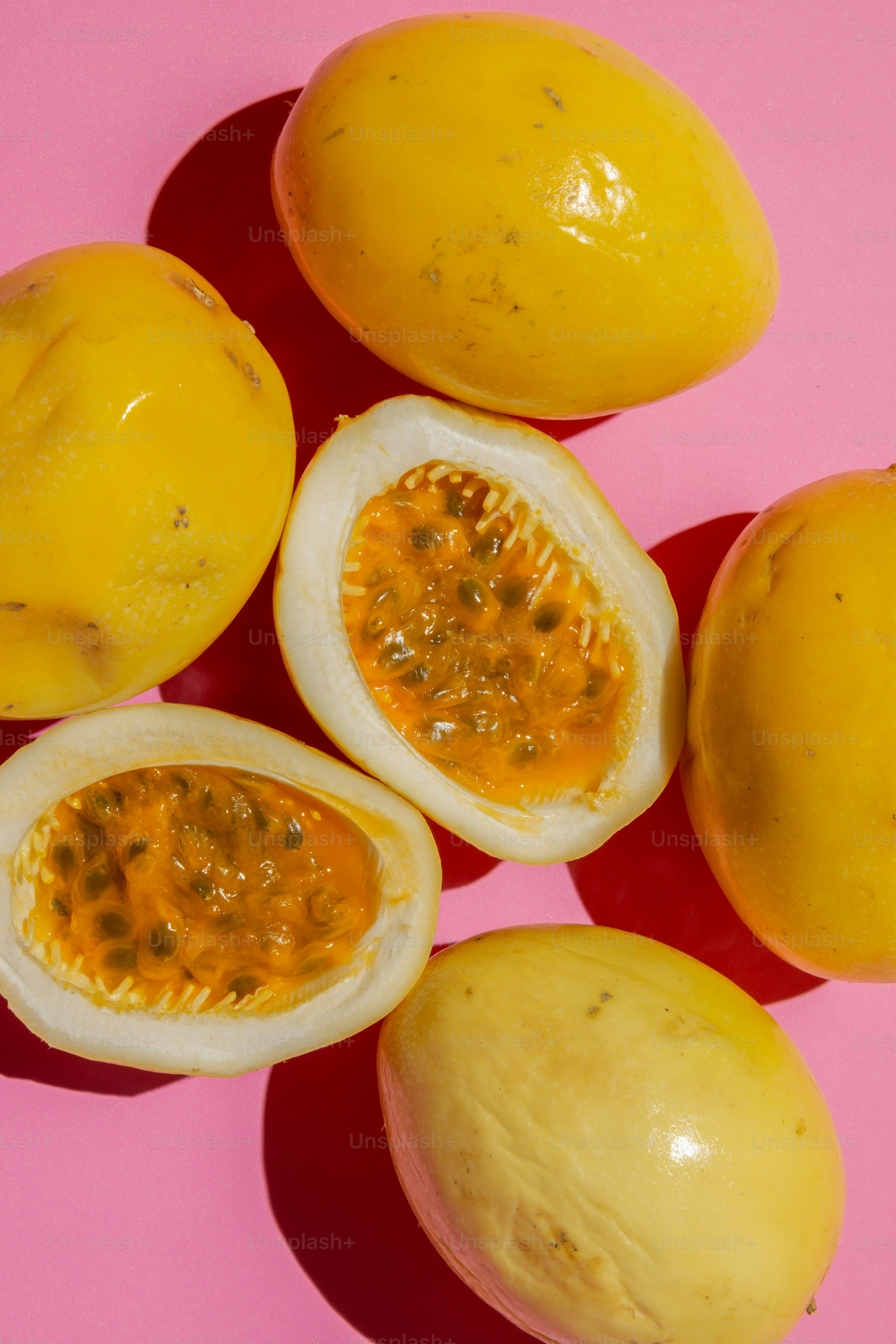 A group of lemons sitting on top of a pink surface