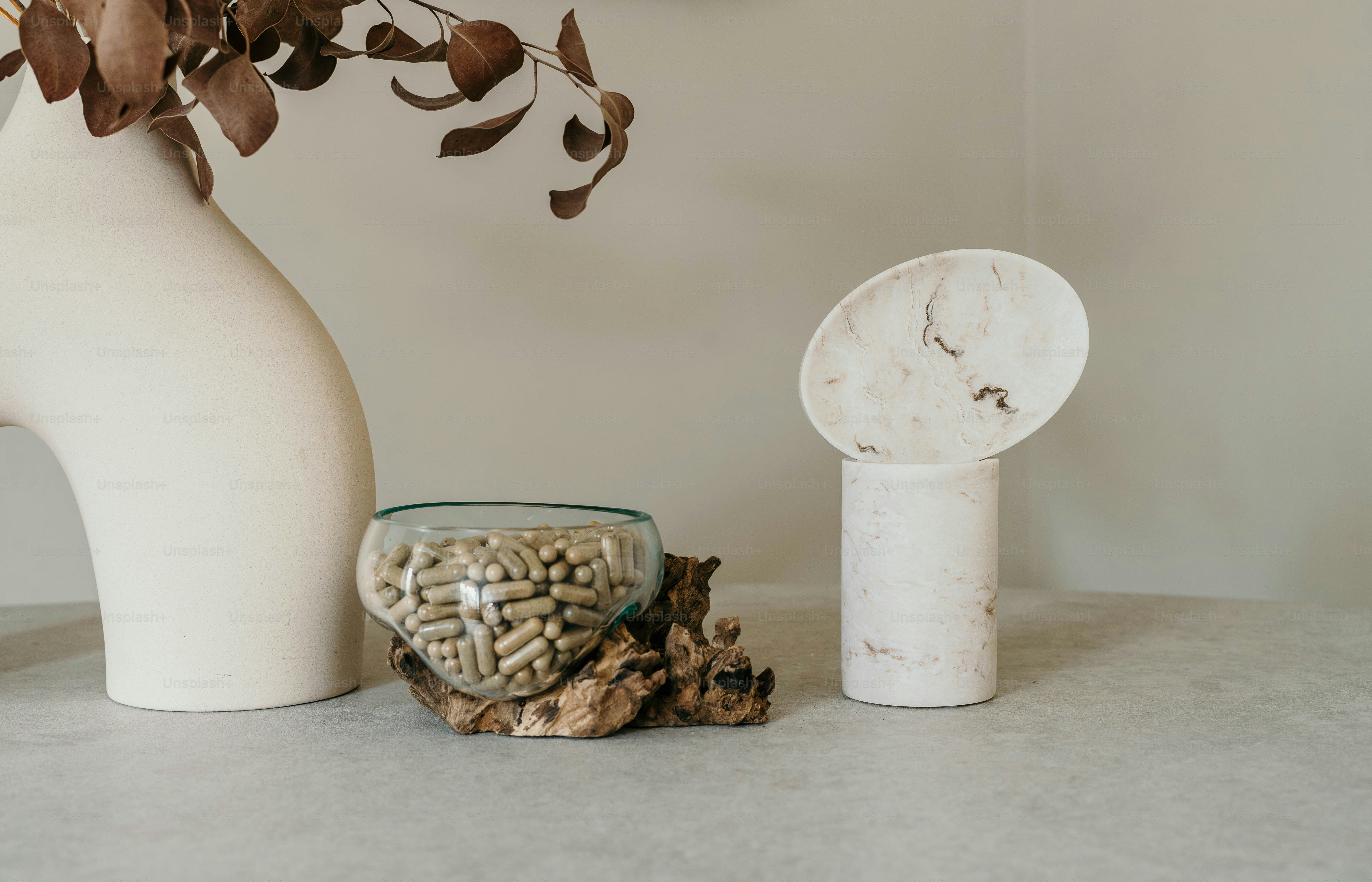 Eine weiße Vase mit Blumen darin neben einer Uhr