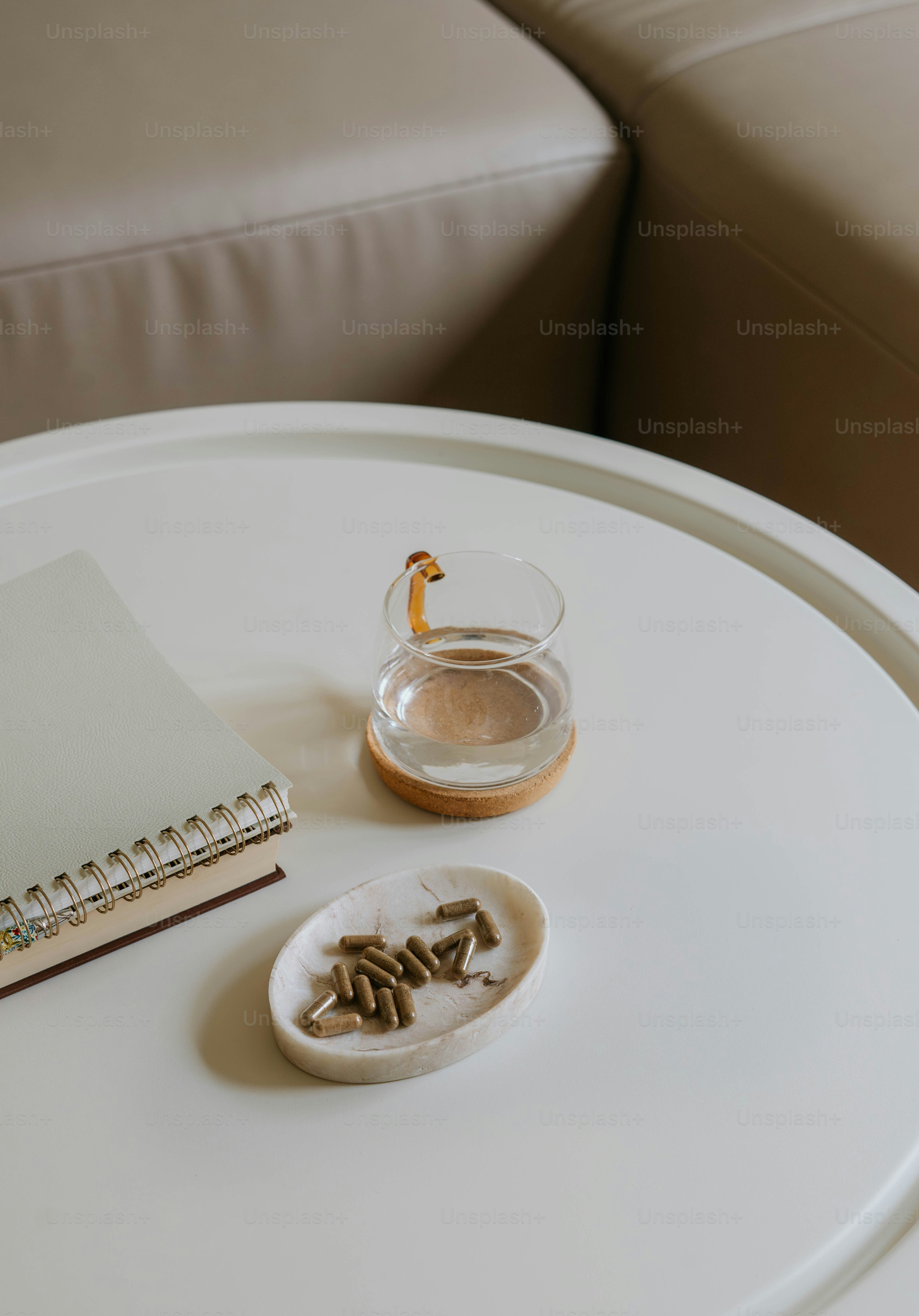 Ein weißer Tisch mit einem Buch und einem Glas Wasser darauf