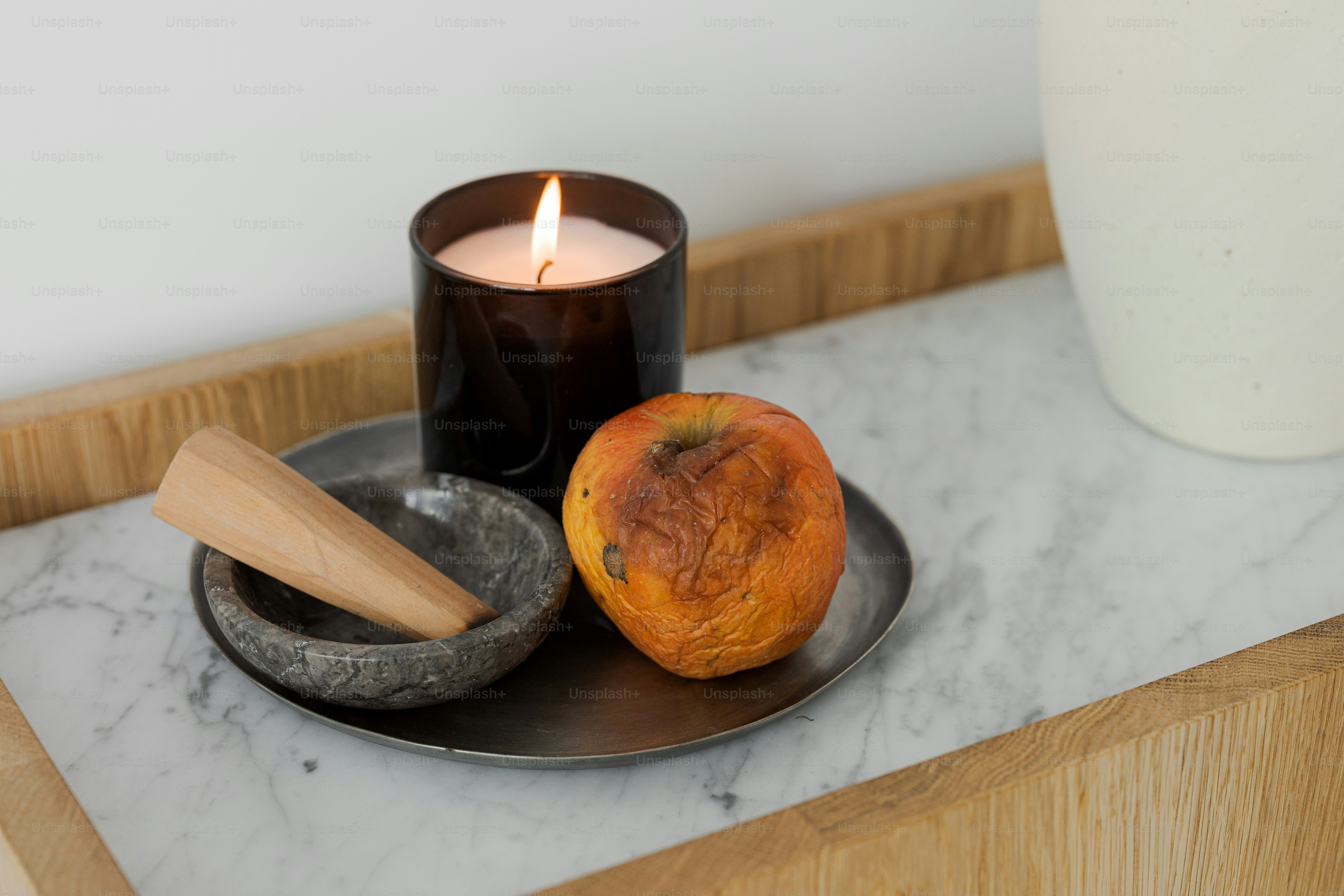 A candle and some fruit on a plate