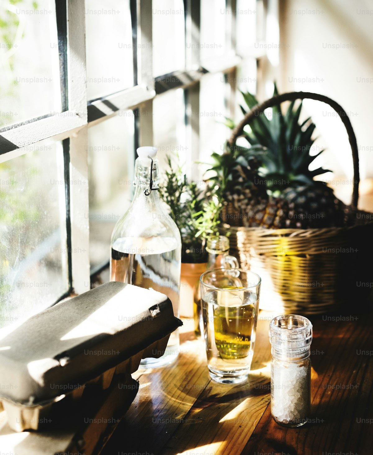 Eggs and cooking oil by a glass window, real-food staples by daylight