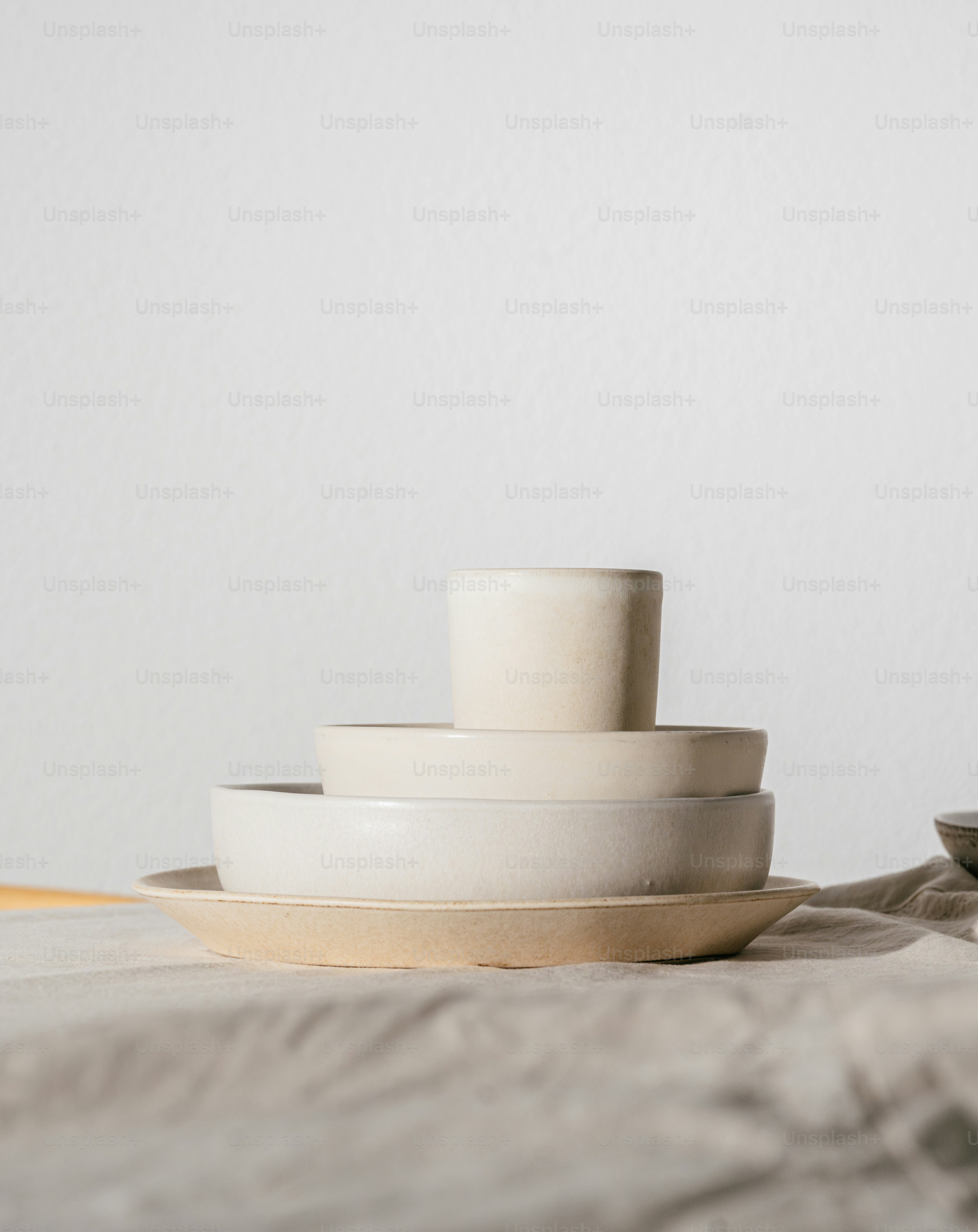 A stack of white plates sitting on top of a bed