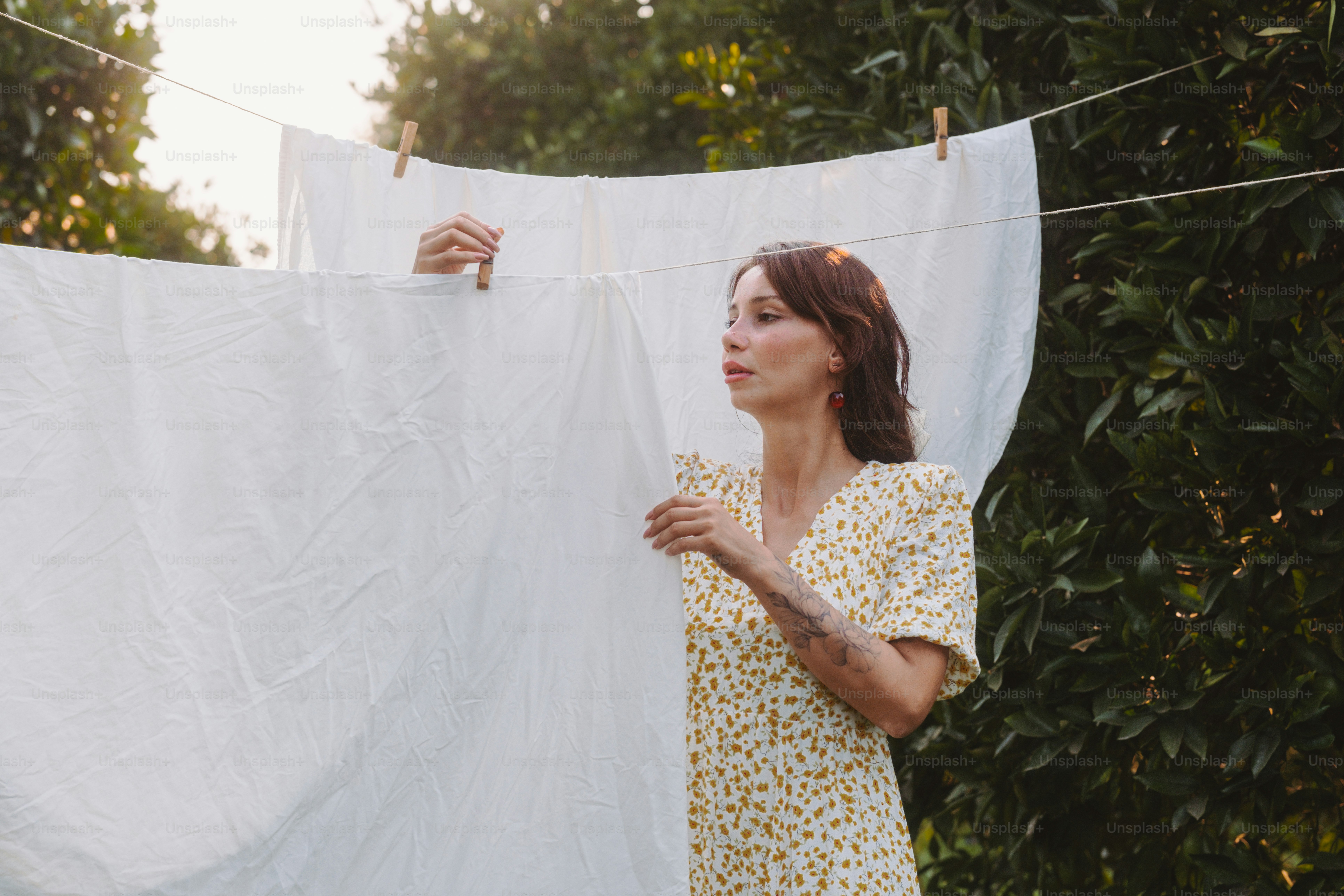 A woman hanging out clothes on a clothes line