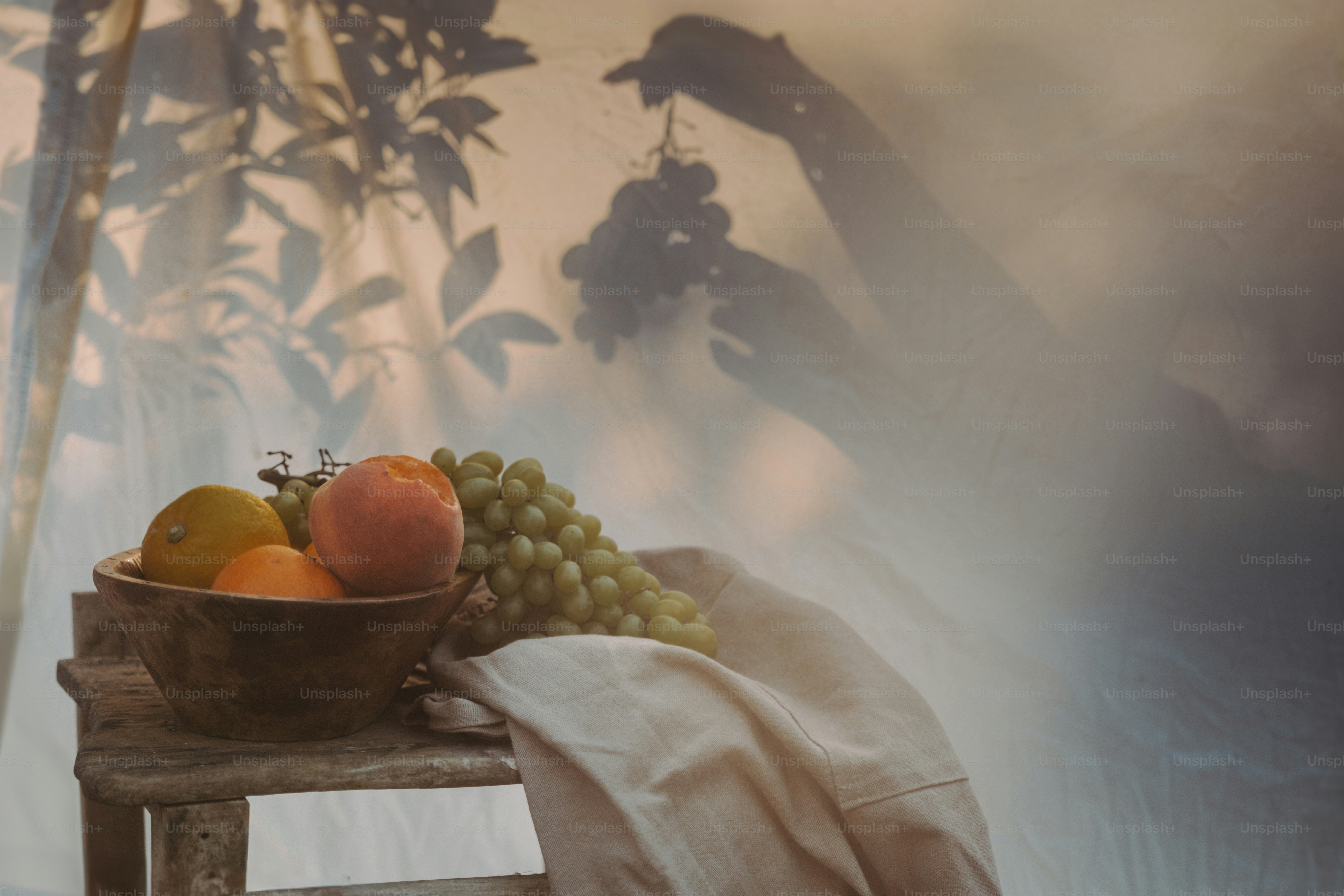 A wooden table topped with a bowl of fruit