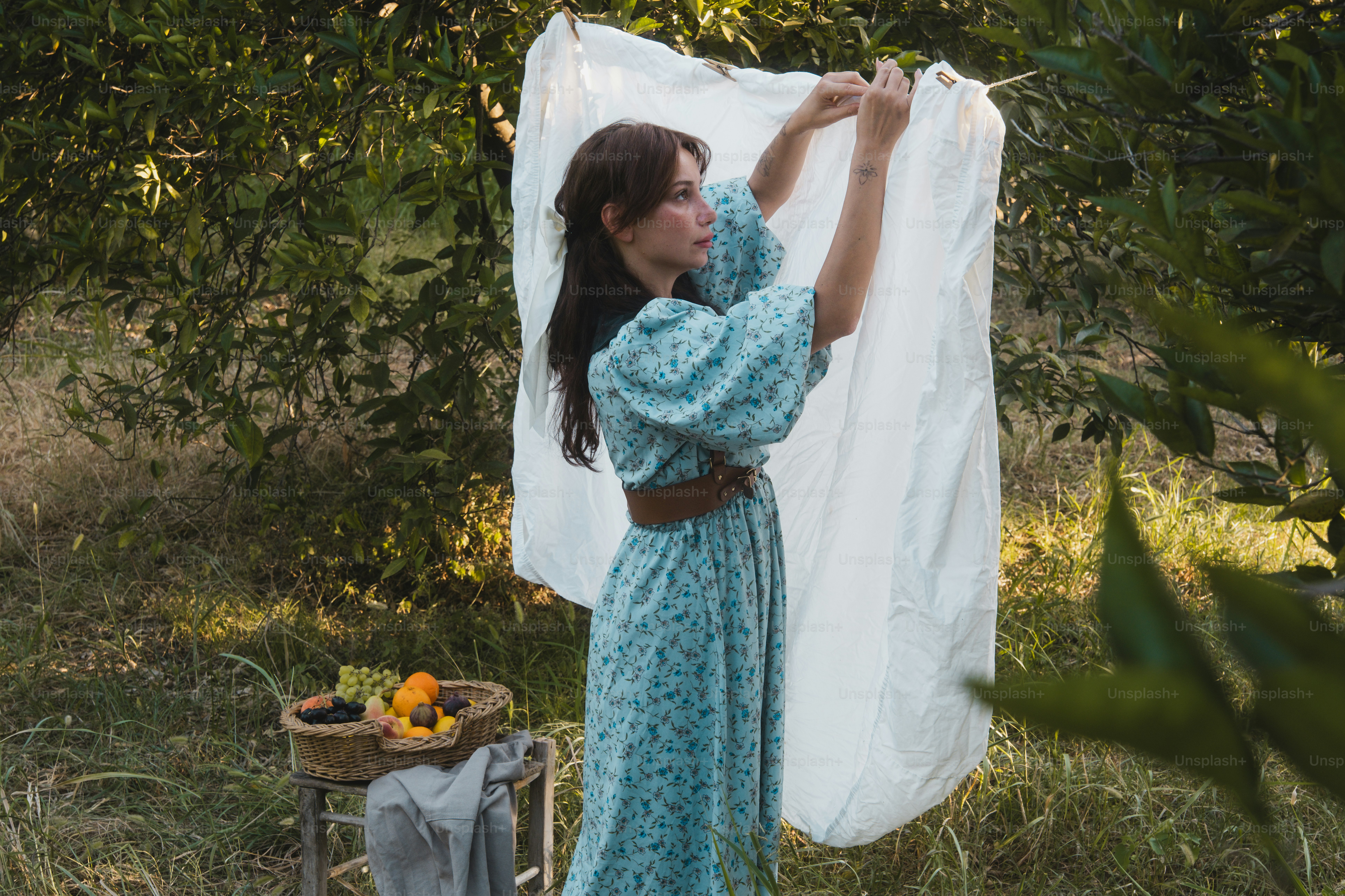 A woman in a blue dress holding a white sheet