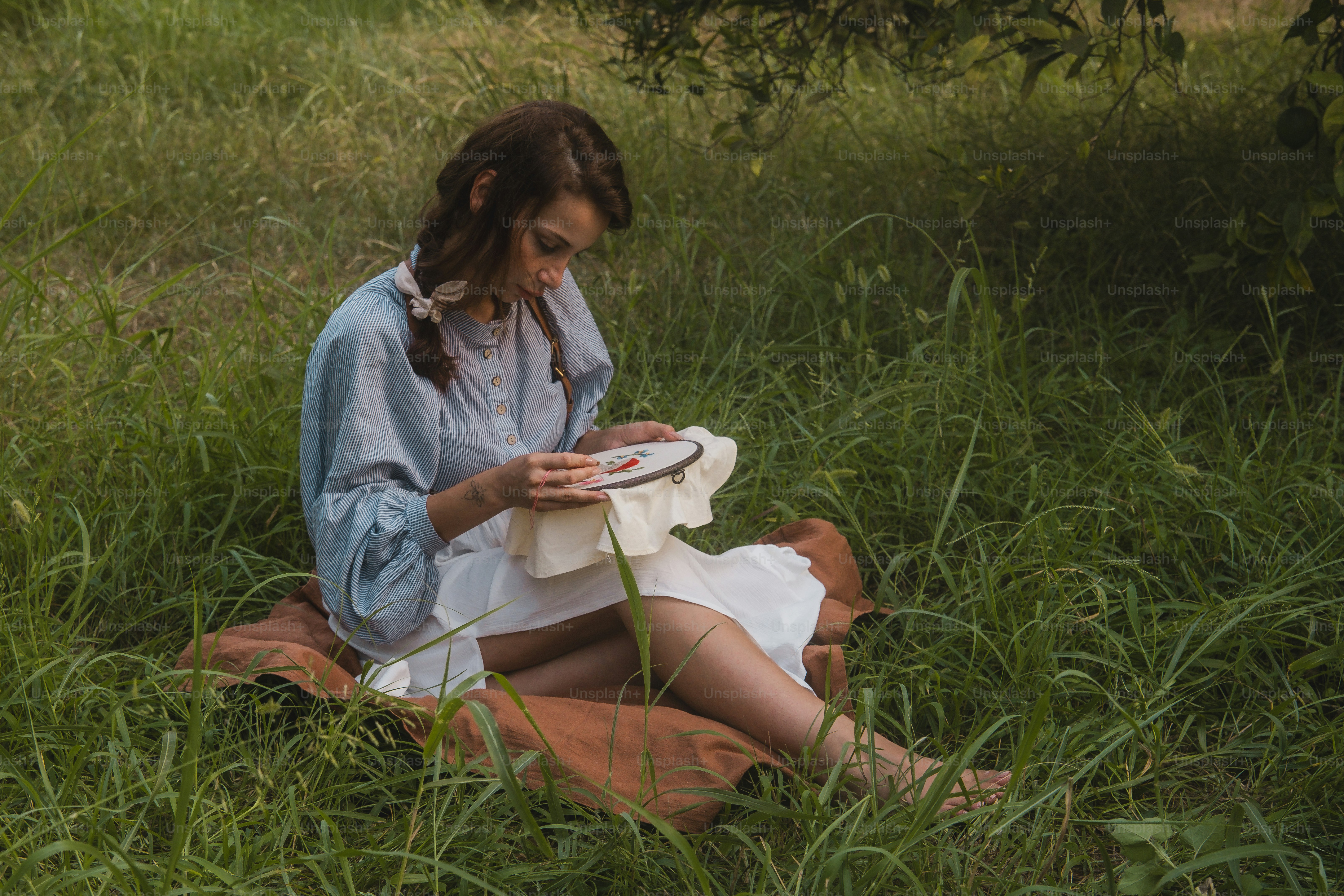 A woman sitting in the grass reading a book