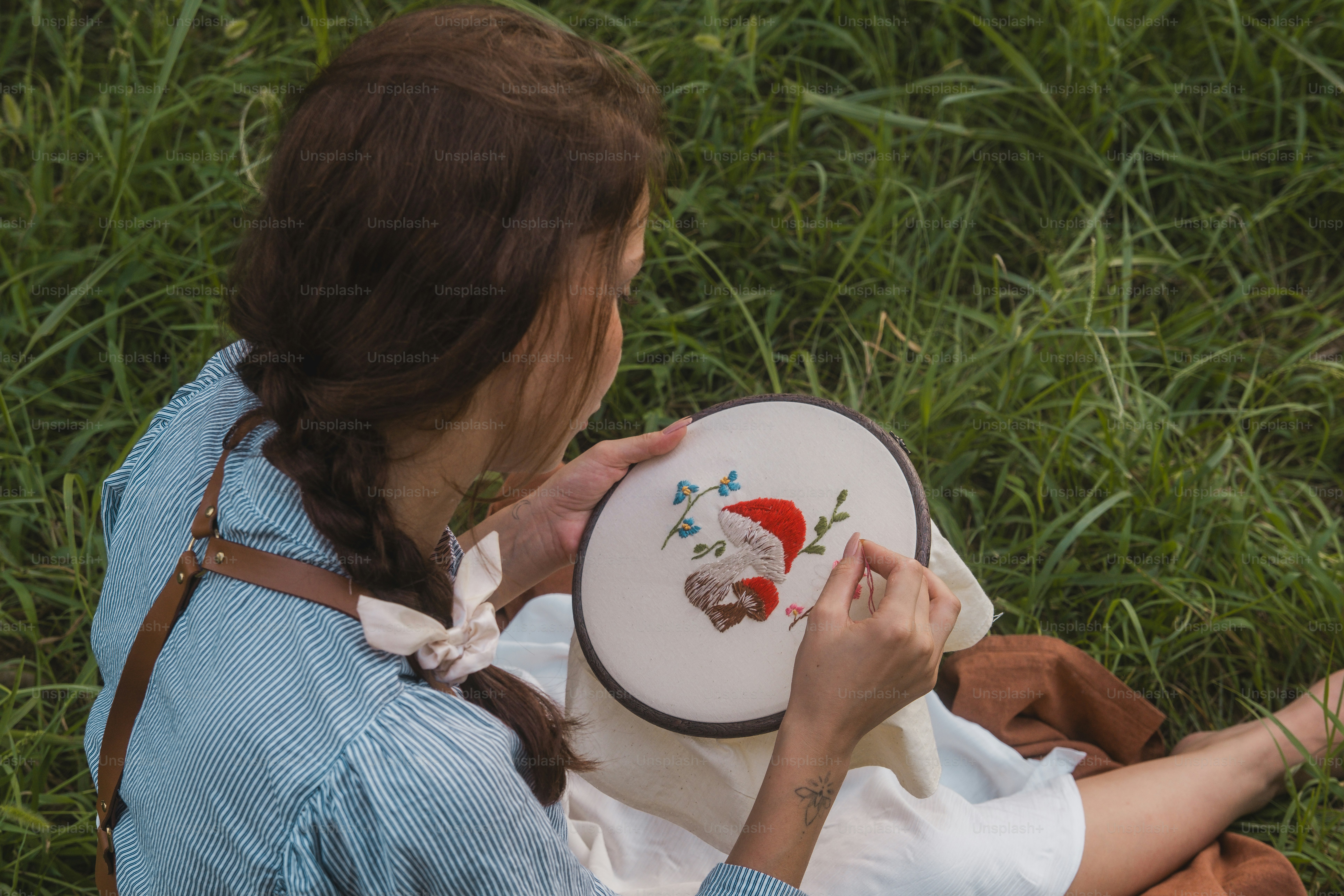 A woman sitting in the grass holding a frisbee