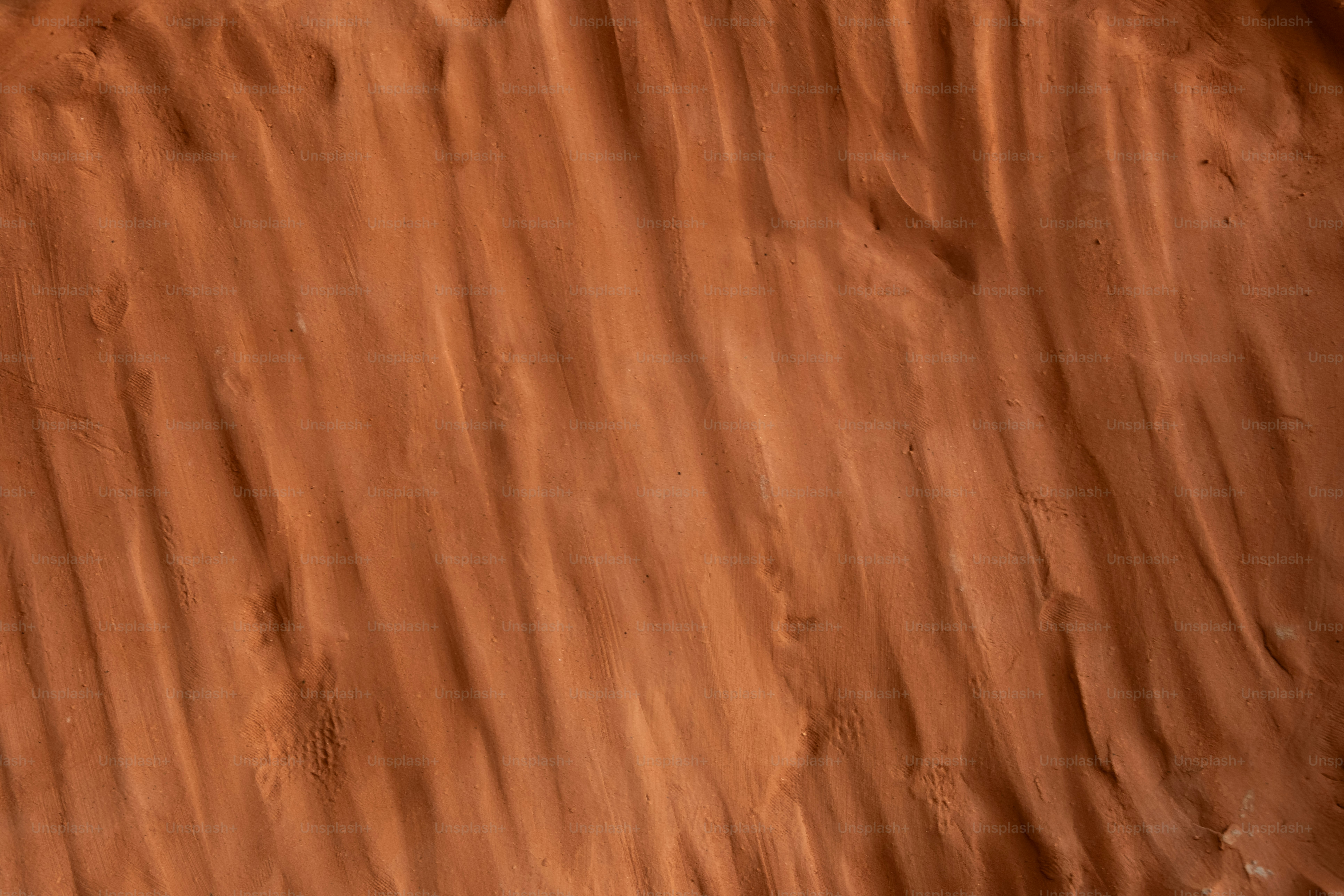 A blurry photo of a desert with a bird flying over it