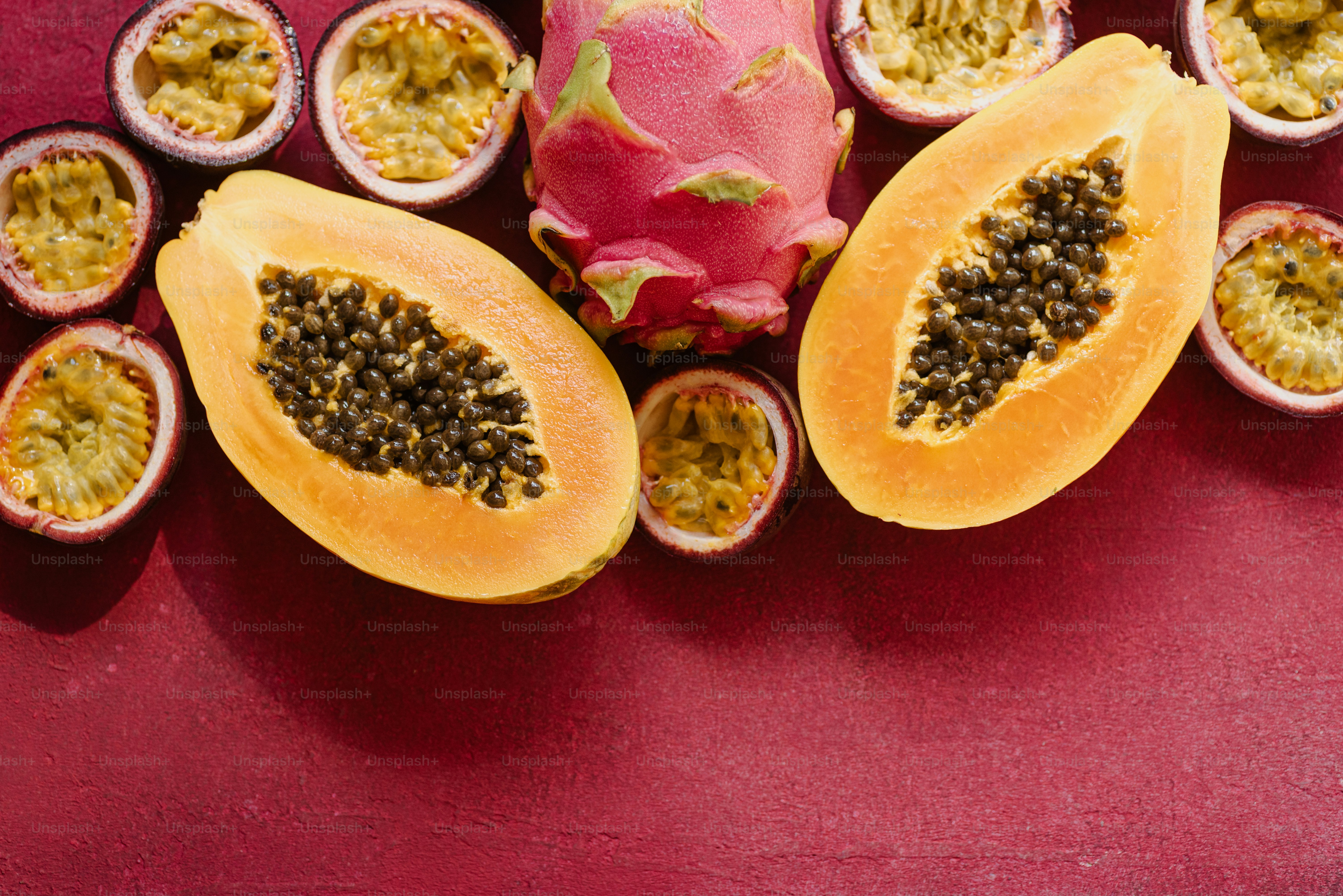 Uma fruta do dragão cortada ao meio em uma superfície vermelha