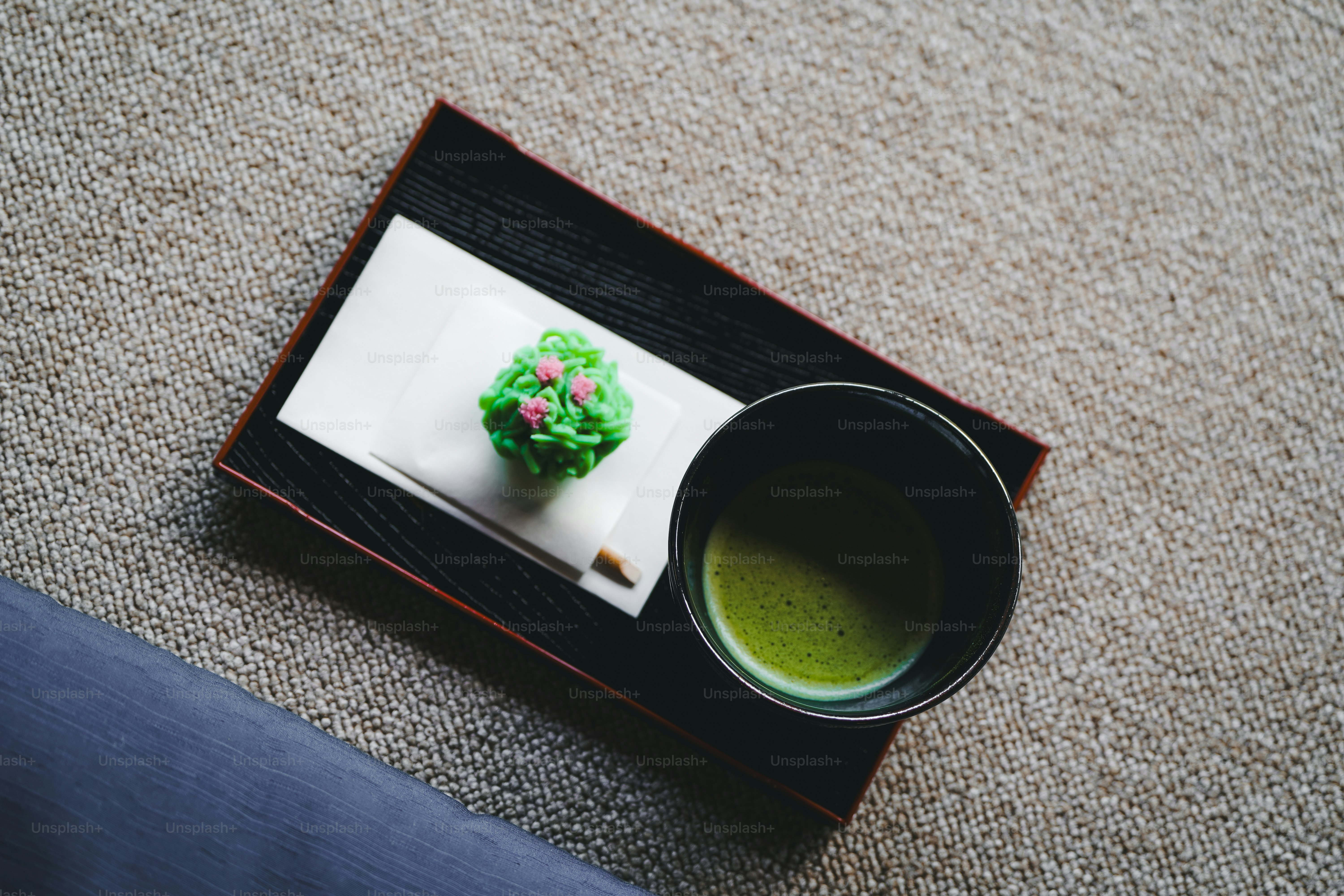 A cup of green tea sitting on top of a coaster