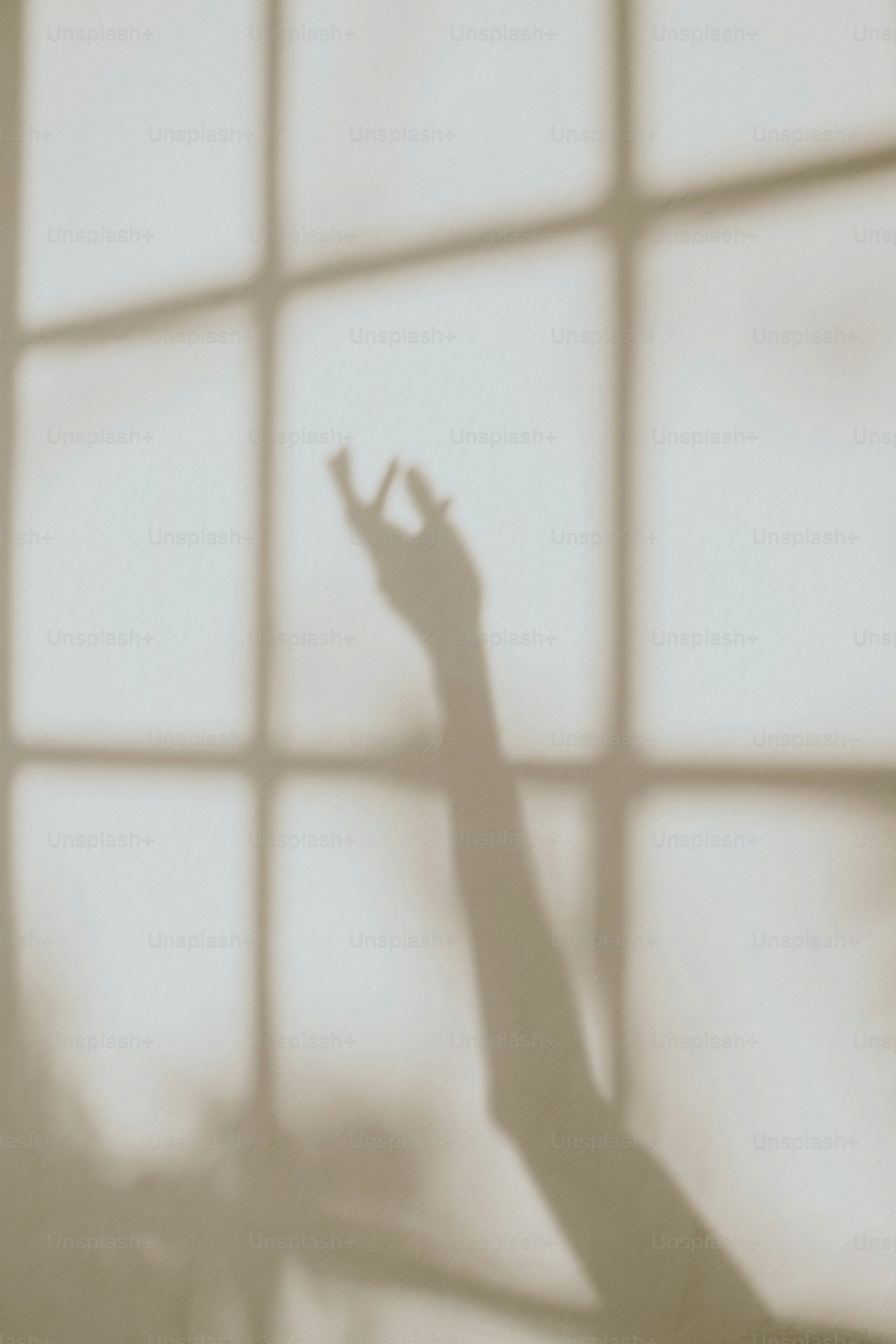 A shadow of a hand reaching out of a window