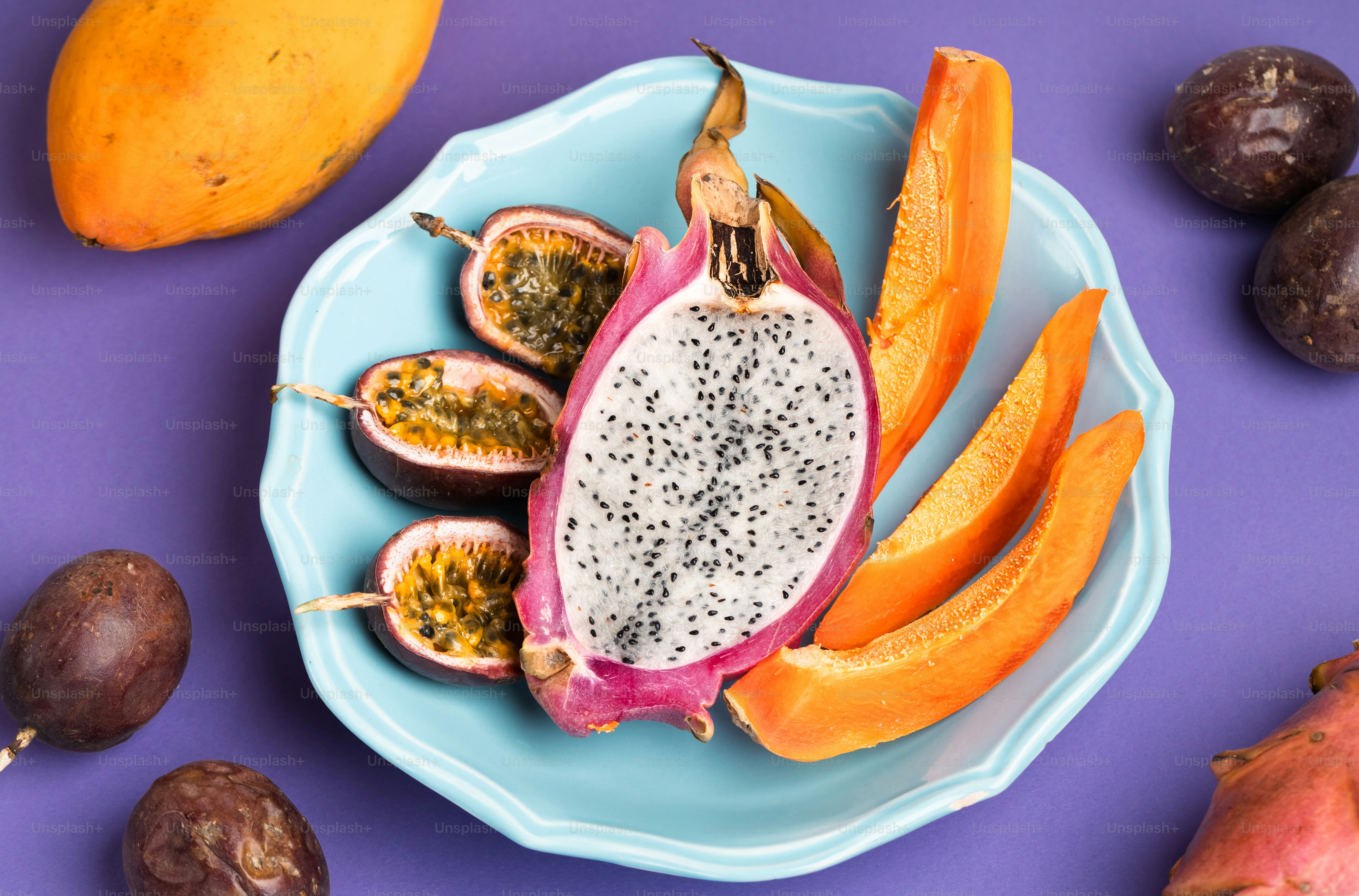 A blue plate topped with a cut in half dragon fruit