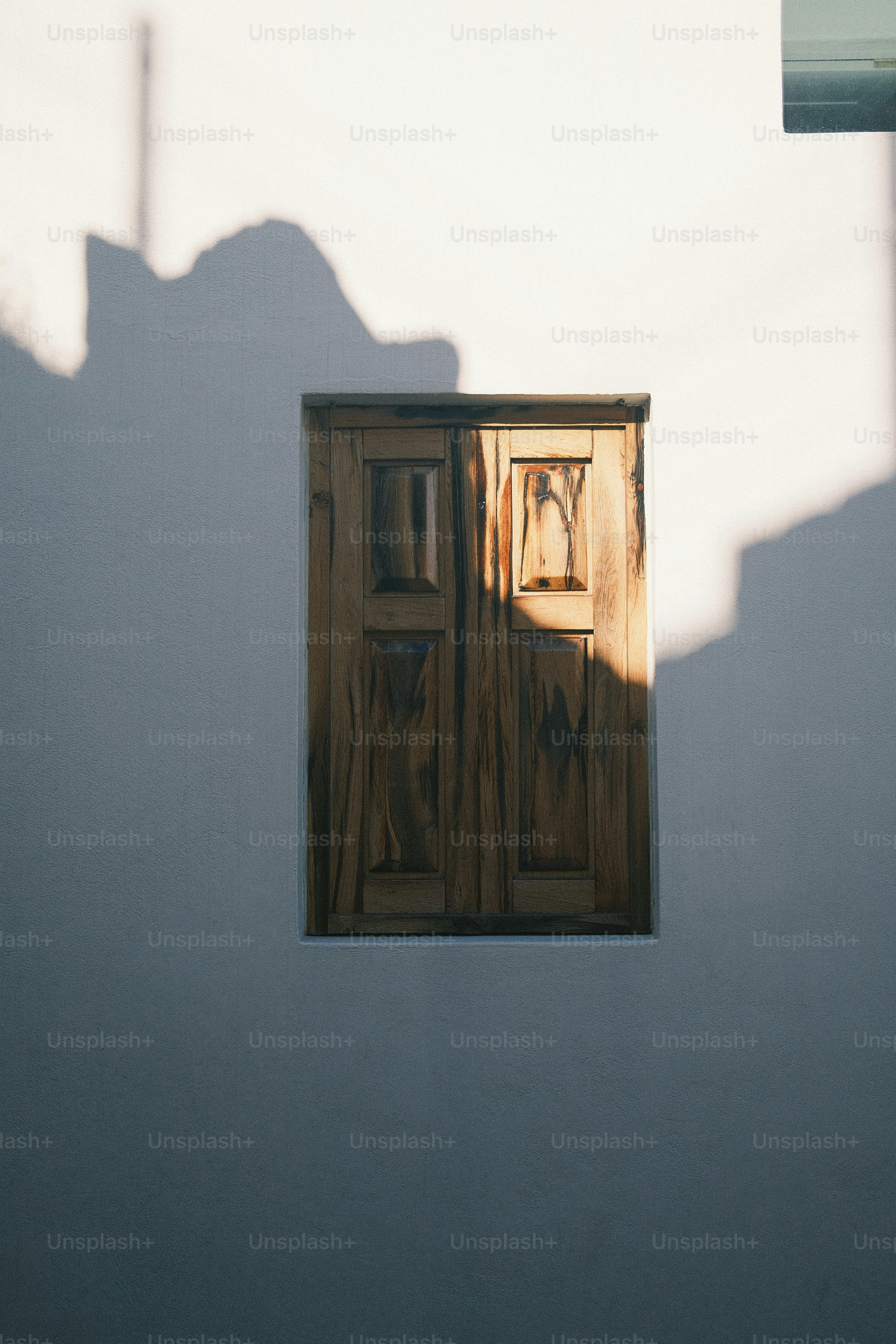 The shadow of a building with a door and window