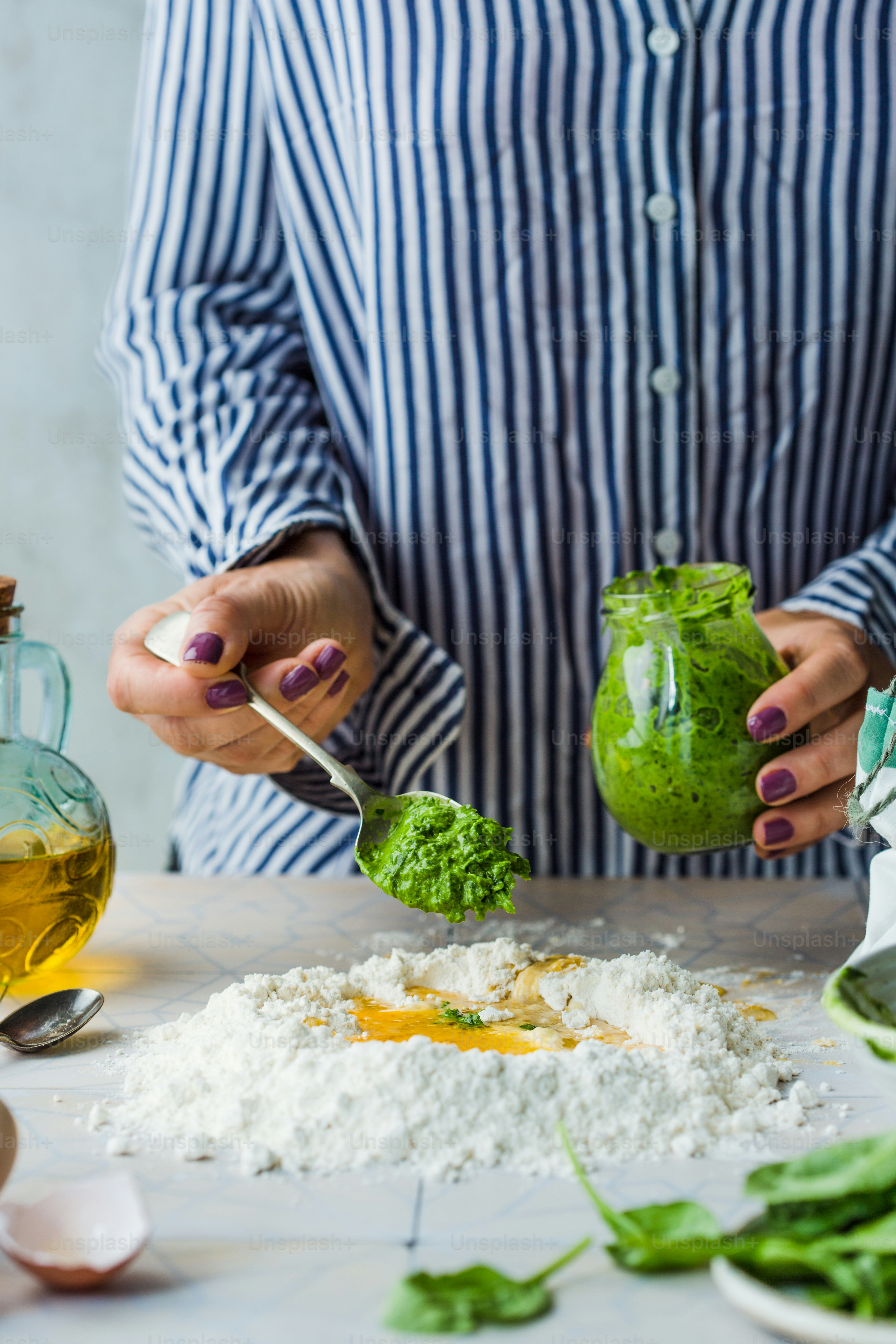 A woman is holding a jar of green food
