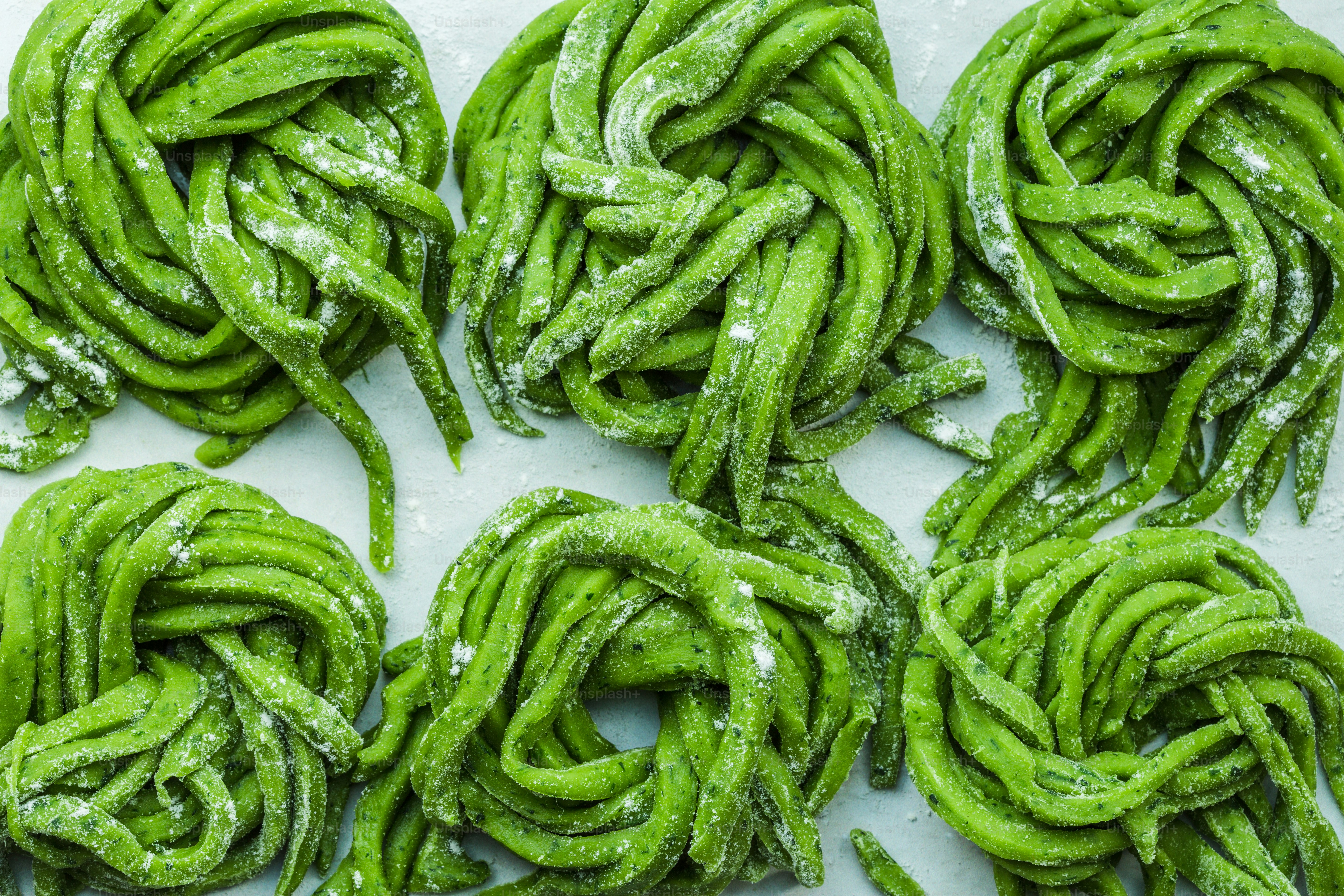 Un montón de pasta verde encima de una mesa